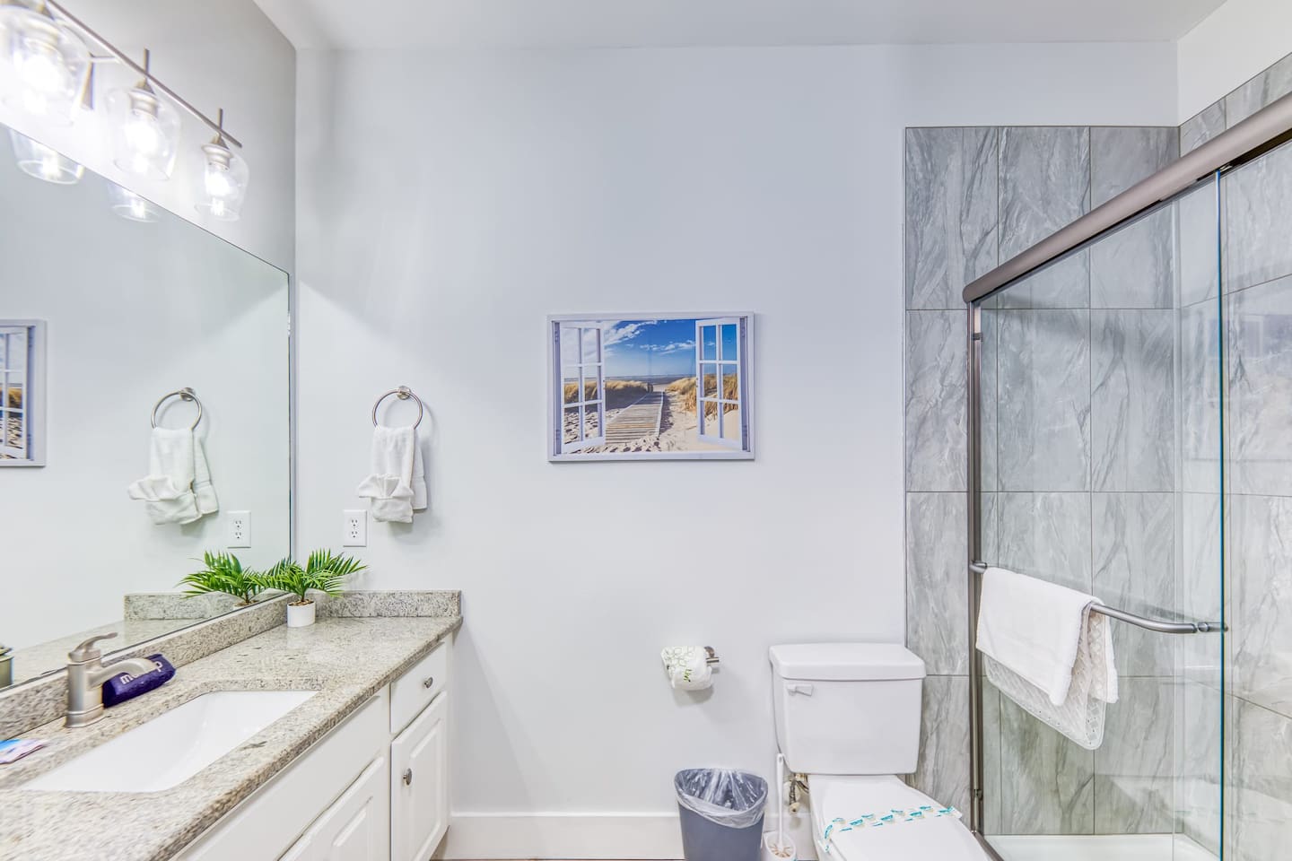 Luxurious Bathroom: Sleek finishes, modern fixtures, and beachy art create a refreshing retreat!
