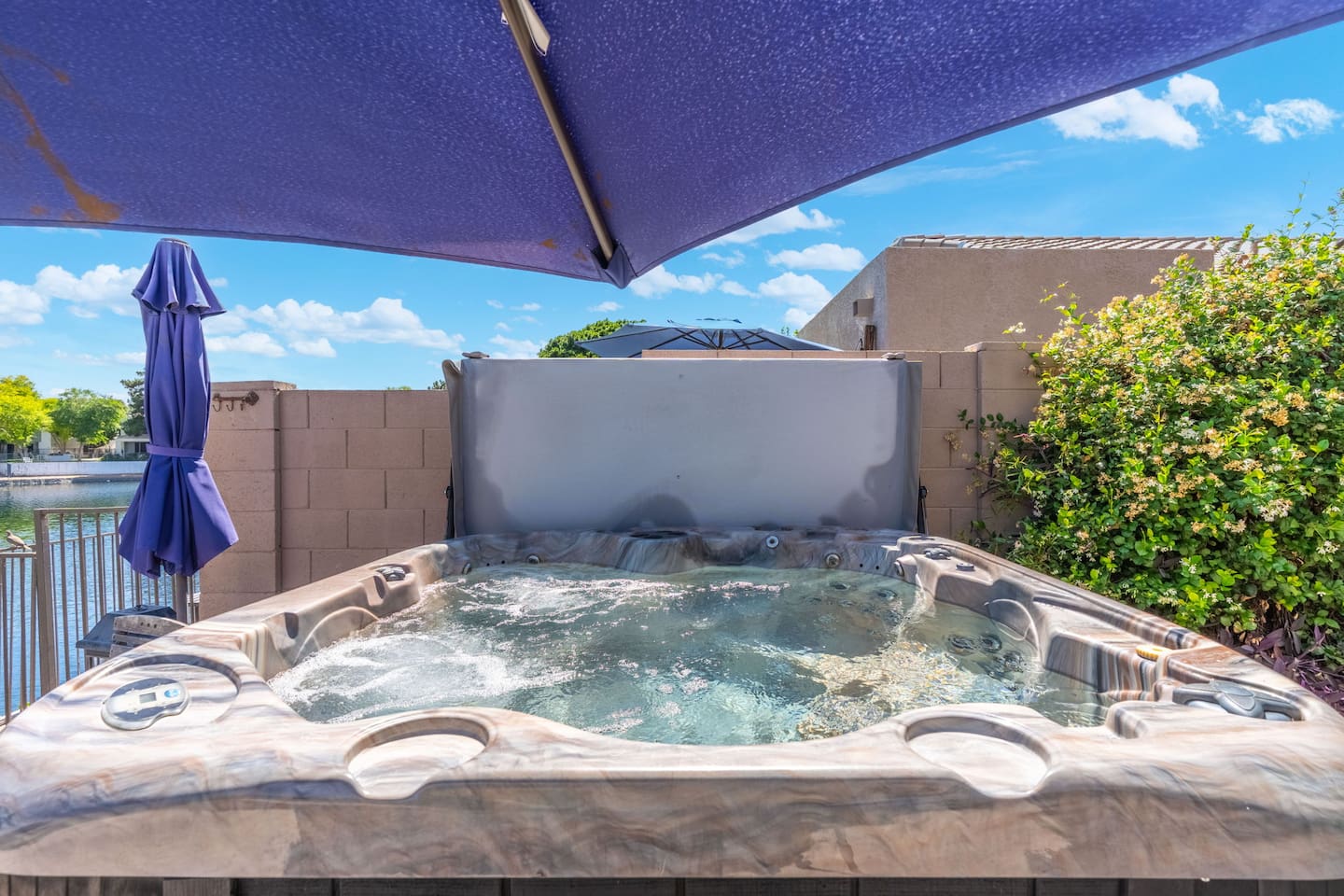 Tucked under a shade sail with a peek of the lake beyond, the hot tub is a private little escape — fire it up day or night for a long, well-deserved soak.