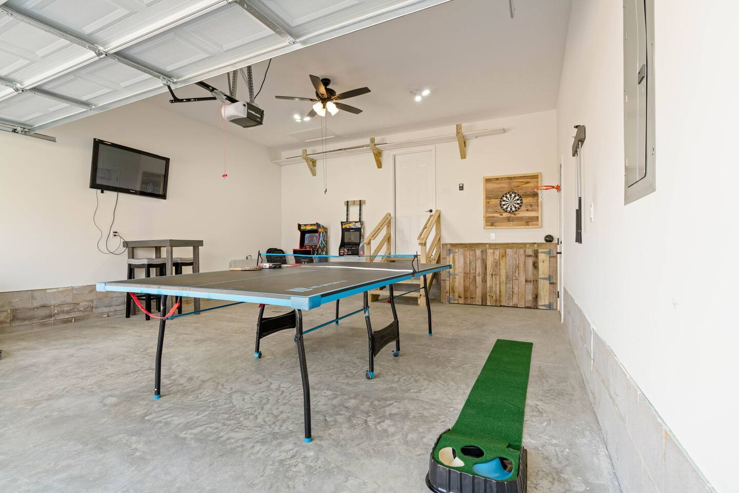 entertainment garage. featuring ping pong, putt putt, darts, tv, arcade games, basketball. Also outdoor games such as cornhole boards, chipping game, etc.