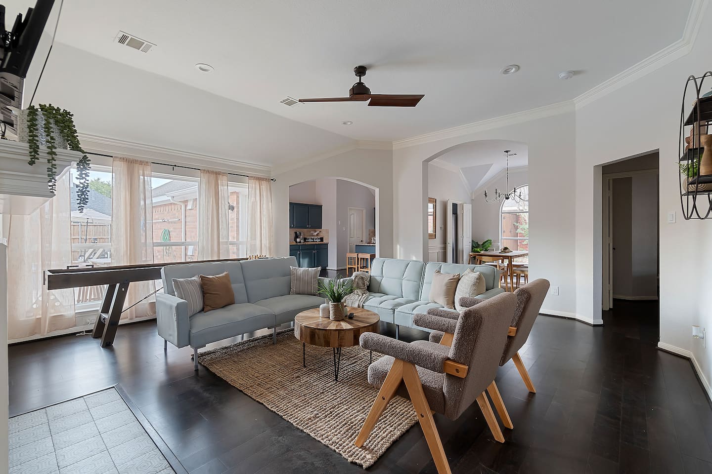 Welcome to our inviting living space with cozy sofas and a sleek TV setup. Shaded windows bring in just the right amount of natural light, creating a perfect balance of comfort and ambiance.
