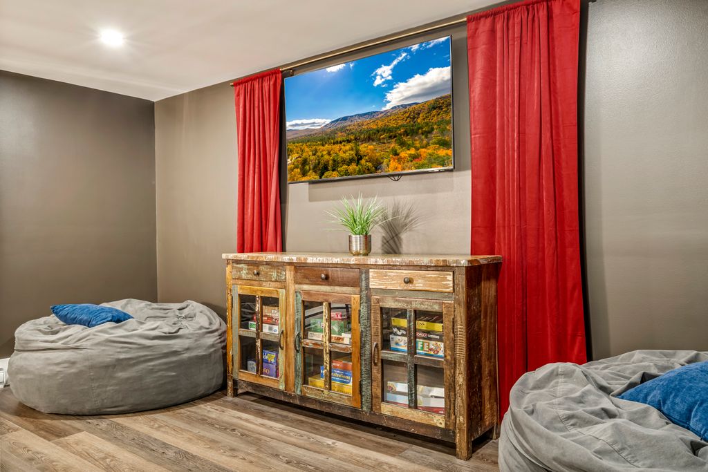 Spacious media lounge with oversized sectional, Smart TV, and beanbag seating — perfect for family movie nights, game time, or a cozy evening in after exploring Bethel