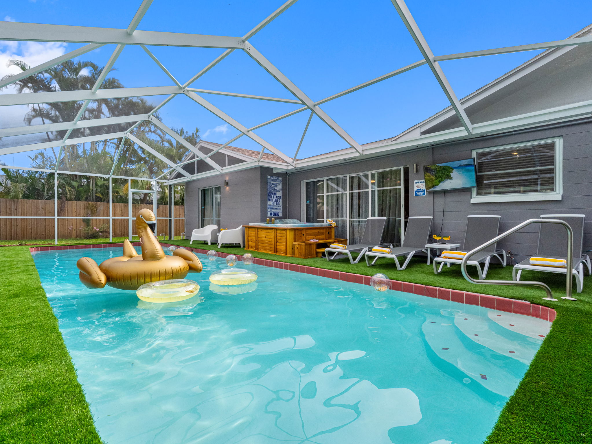 Lounge in style beneath a screened lanai, with crystal-clear waters, comfy chairs, and a golden float that screams vacation.