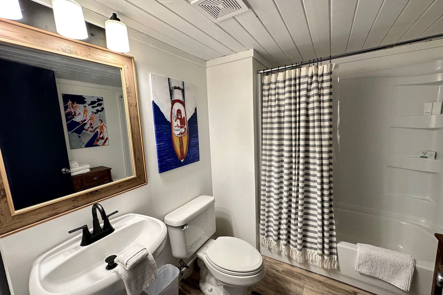 Clean, stylish bathroom with fresh towels, a full tub/shower combo, and fun nautical art for a playful touch. Thoughtfully stocked and well-lit, it offers everything you need to freshen up and unwind during your stay.