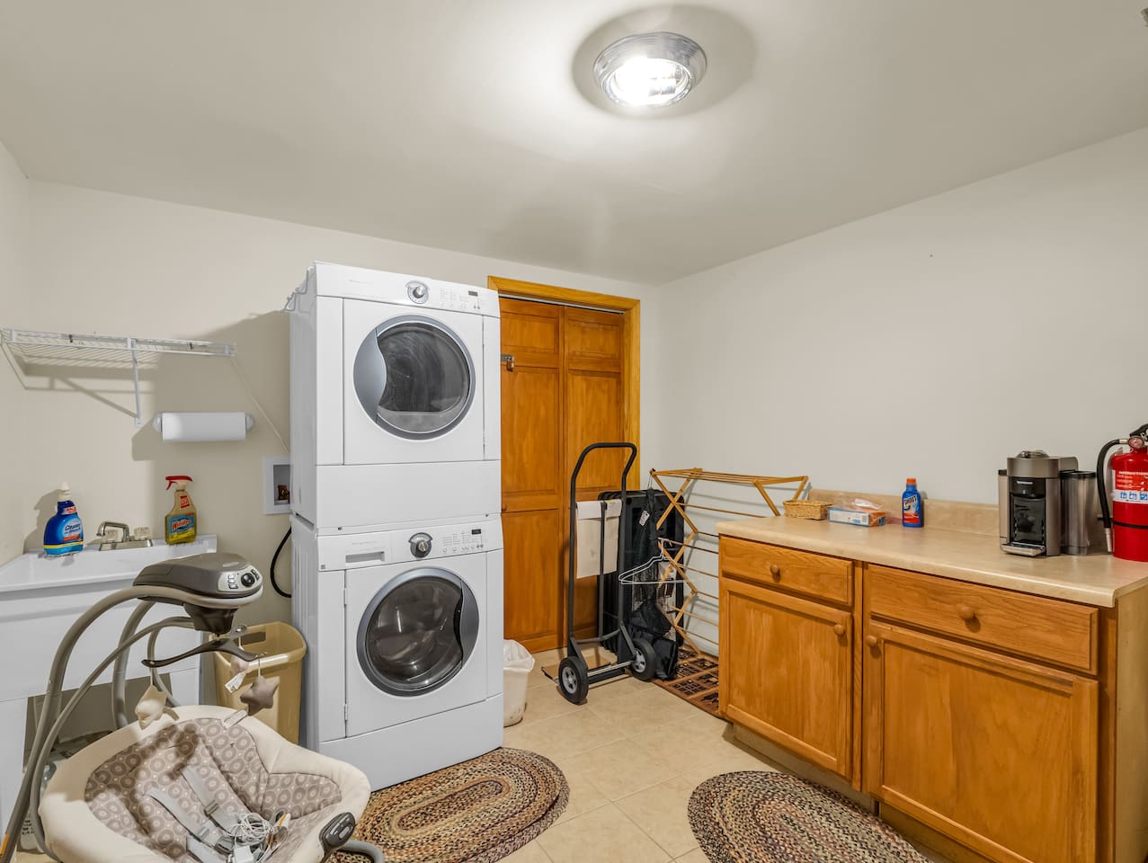 Convenient laundry area with washer/dryer, utility sink, and ample counter space for folding clothes