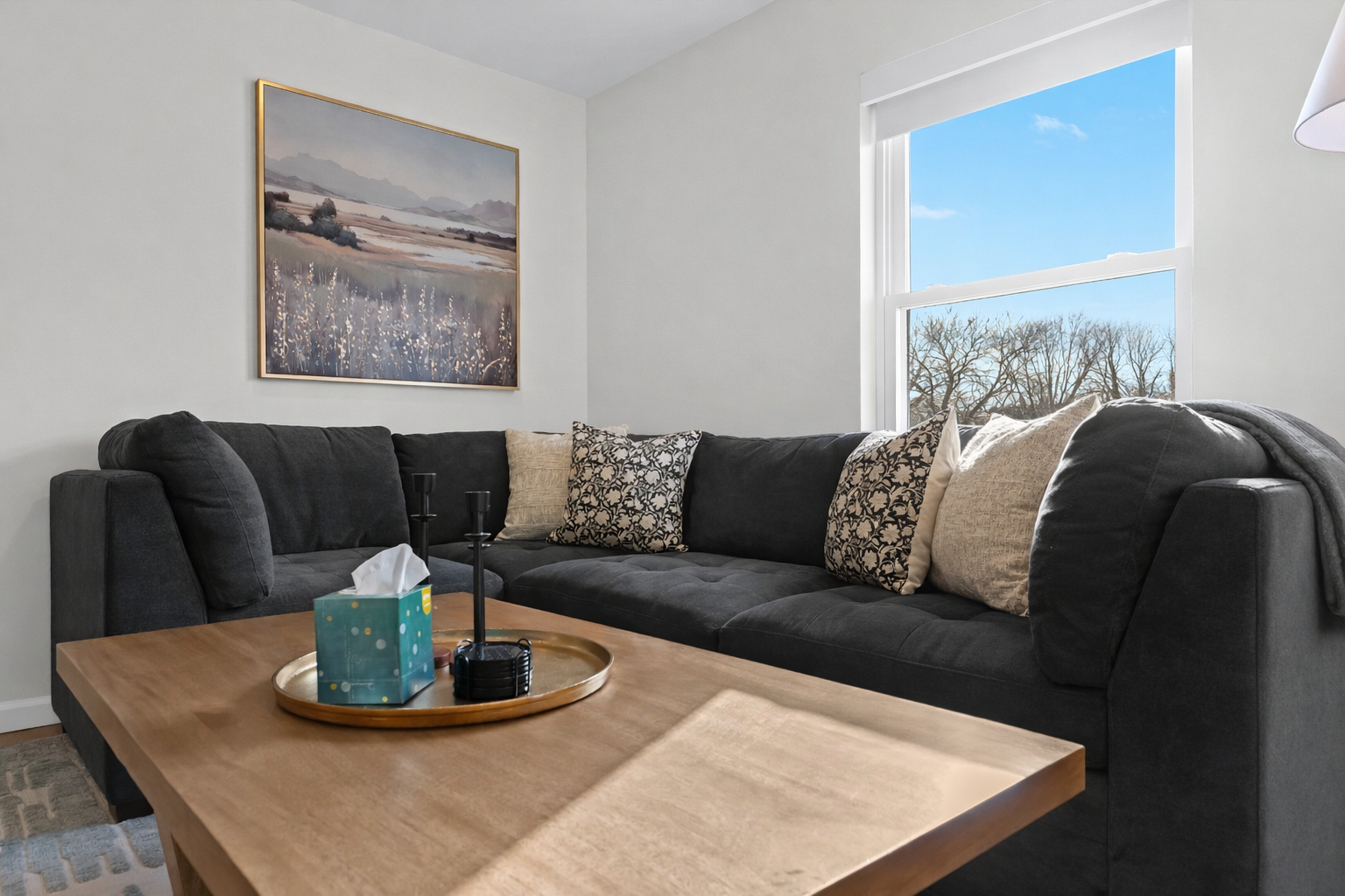 Stretch out on a plush sectional surrounded by natural light, cozy textures, and calming décor—perfect for relaxing after a day exploring the area.