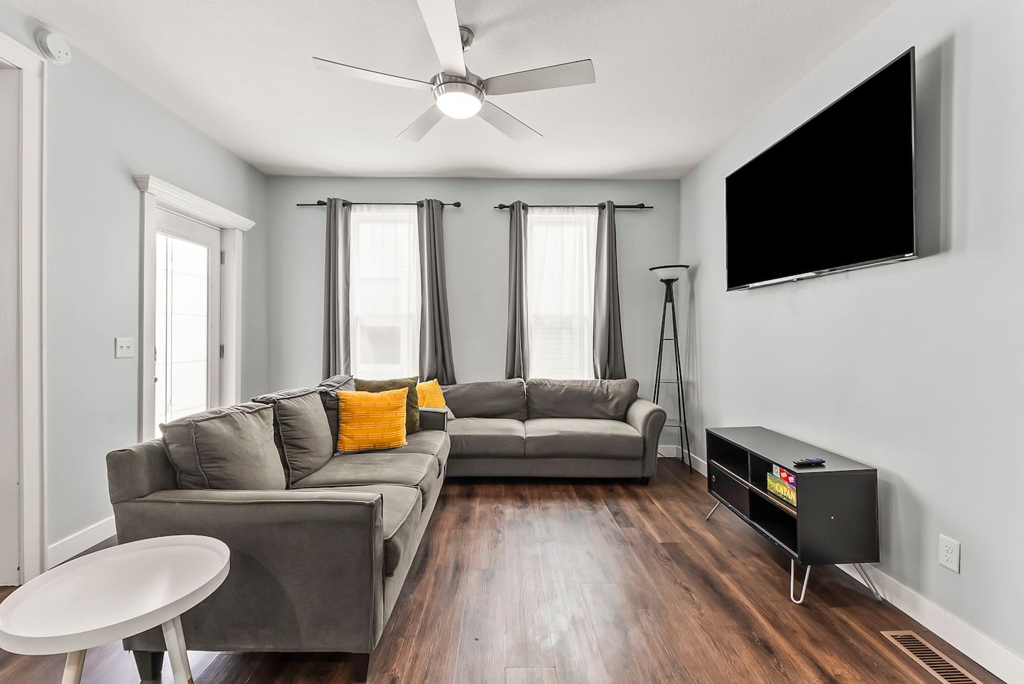 Stylish downtown apartment living room with hardwood floors, plush seating, and a large TV for streaming your favorite shows.