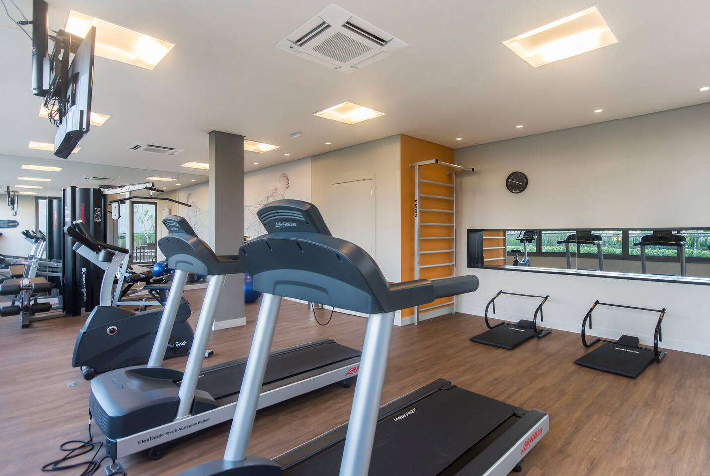 Academia completa com esteiras e equipamentos de cardio no condomínio.