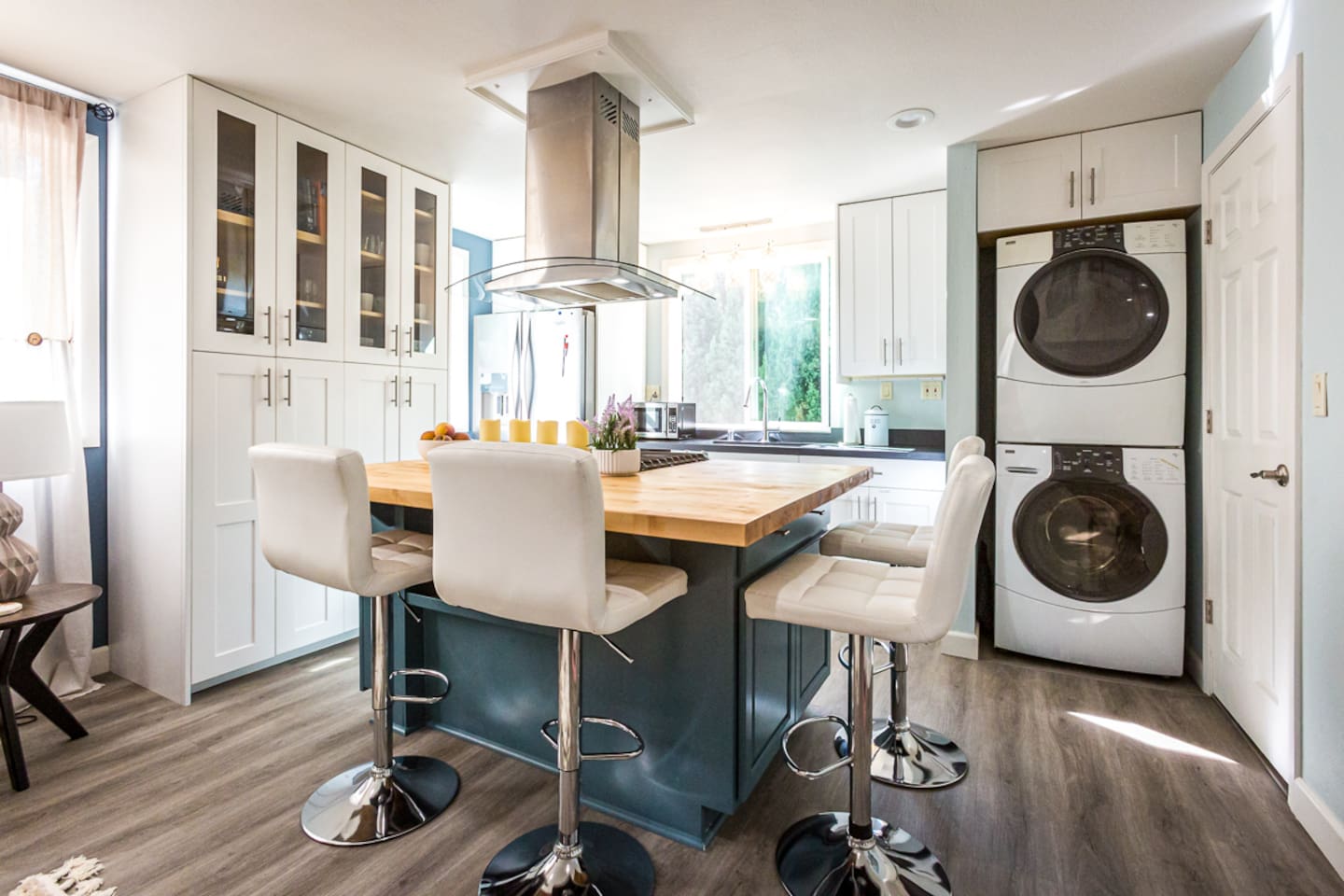 - Modern kitchen with spacious wood island, four chic bar stools, & built in gas cooktop  
- Crisp white cabinetry pairs with stainless steel appliances for a clean, stylish vibe  
- Stacked washer & dryer seamlessly integrated for convenience  
