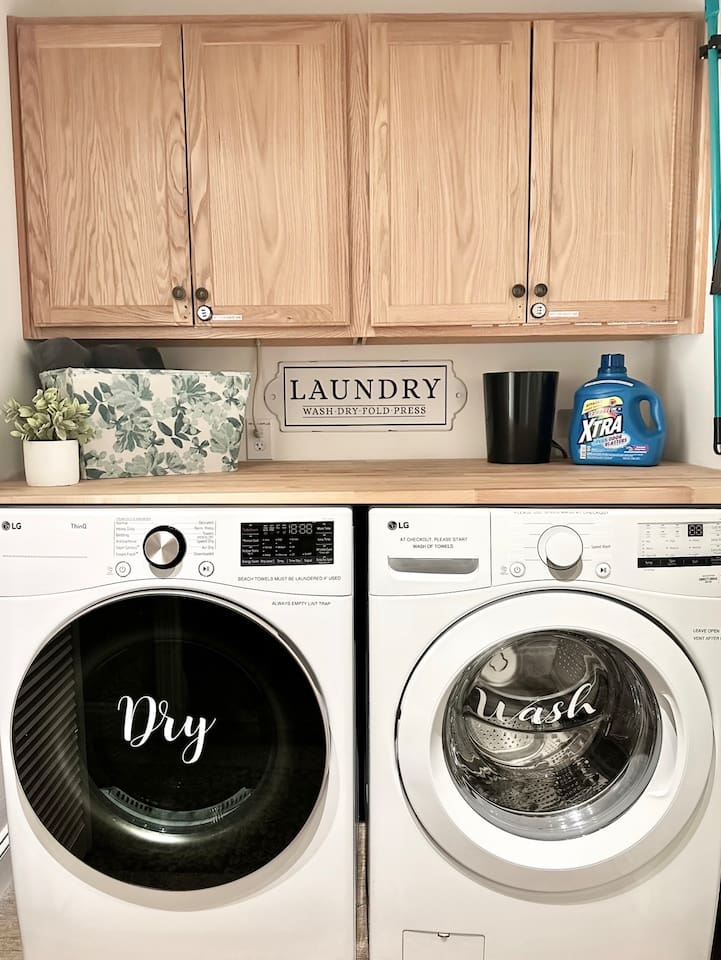 Enjoy the convenience of an in-home laundry station equipped with modern, front-loading LG appliances. This organized space includes a handy folding counter and essential supplies, making it easy to keep clothes fresh and clean during any stay.