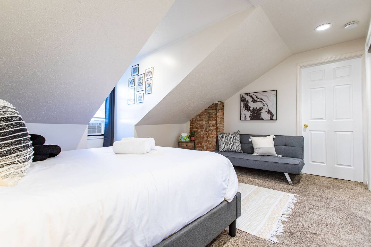 Comfortable bedroom featuring a double bed and a cozy sofa, offering a versatile space to relax, sleep, and unwind.