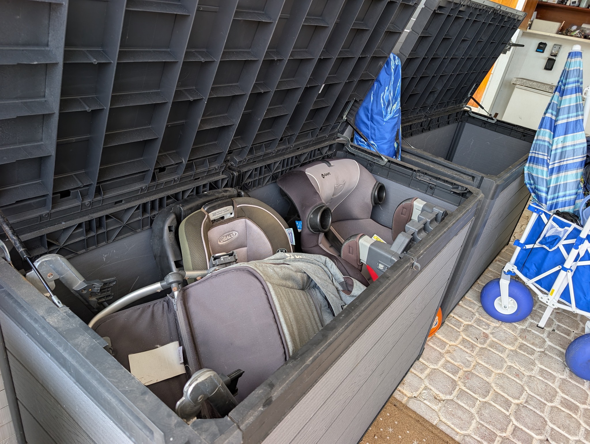 Heavy-duty outdoor storage boxes in the carport at Villa Coral protecting complimentary baby car seats, strollers, and beach wagons from the elements in Dorado, Puerto Rico.