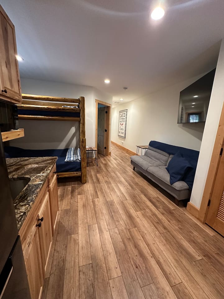 Lower level of the cabin with bunk bed & sofa
This area also has a sink, fridge, & cabinet space.