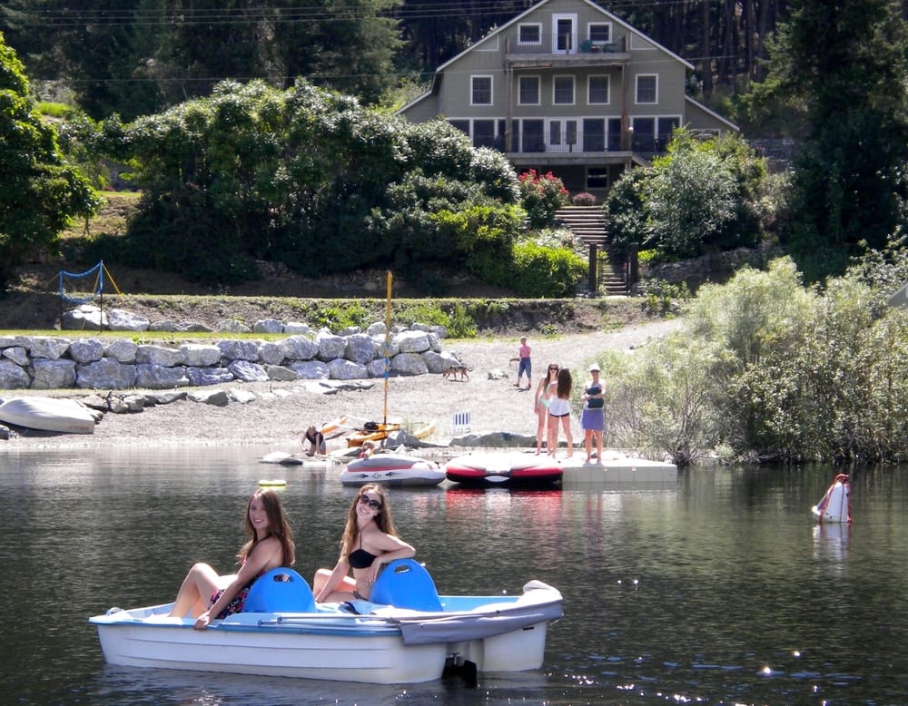 The Lodge at Palmer Lake seen from the water with family at the beach