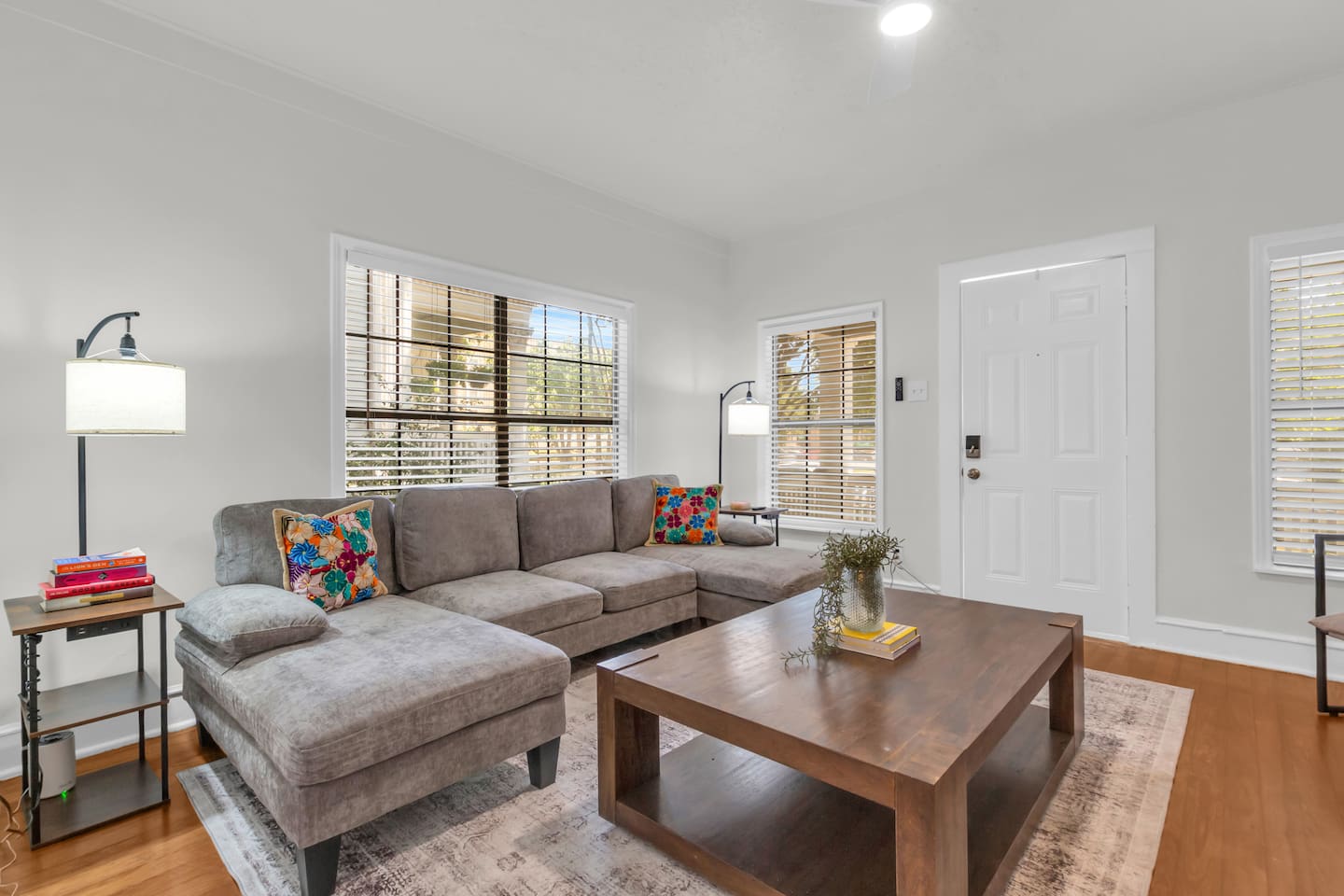 Bright living room with sectional sofa, TV,  and natural light.