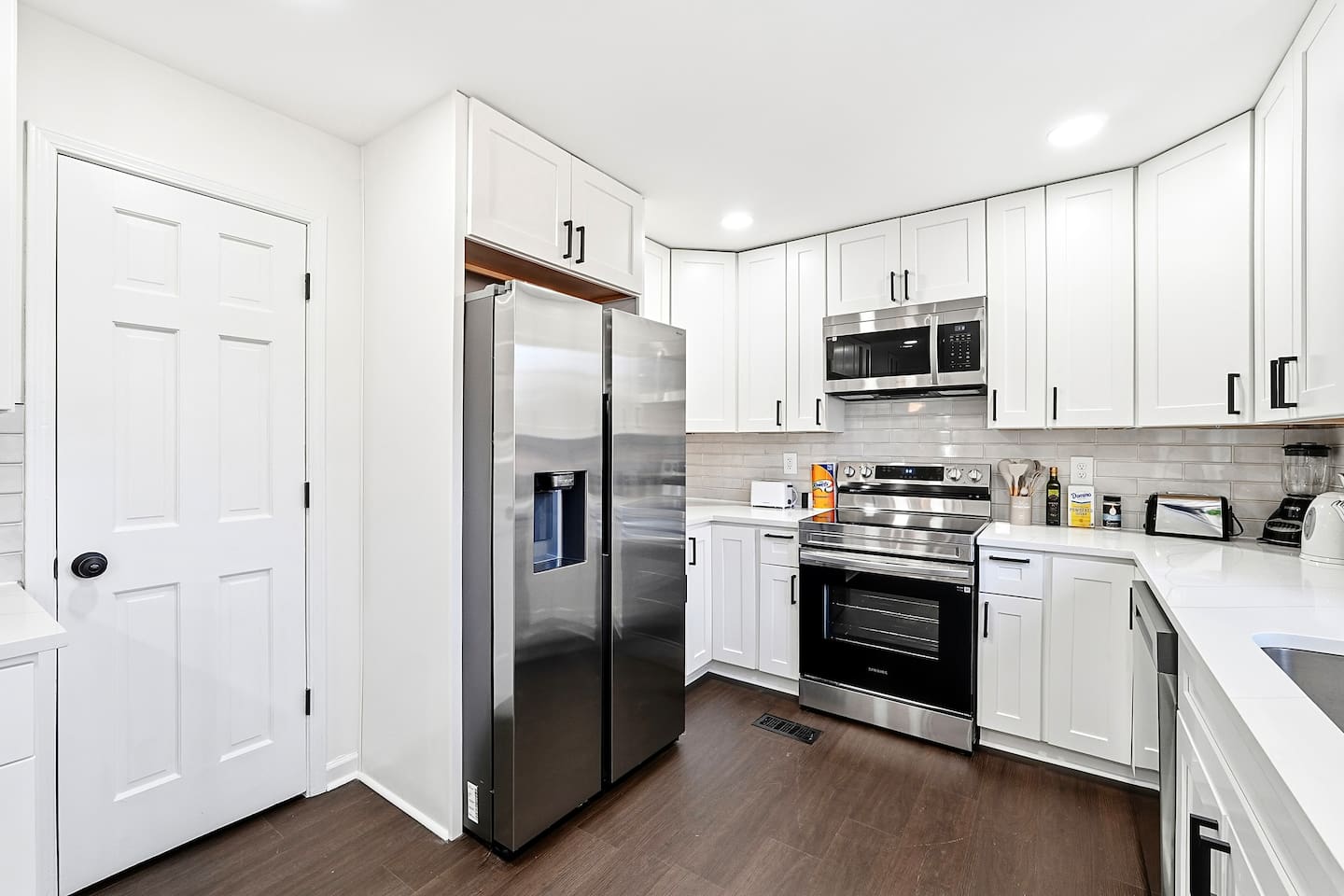 Bright white kitchen with a sleek, extended layout and ample counter space. The long layout offers plenty of countertop space, perfect for cooking, prepping, and everyday meals. Fully stocked with everything you need for a comfortable stay!
