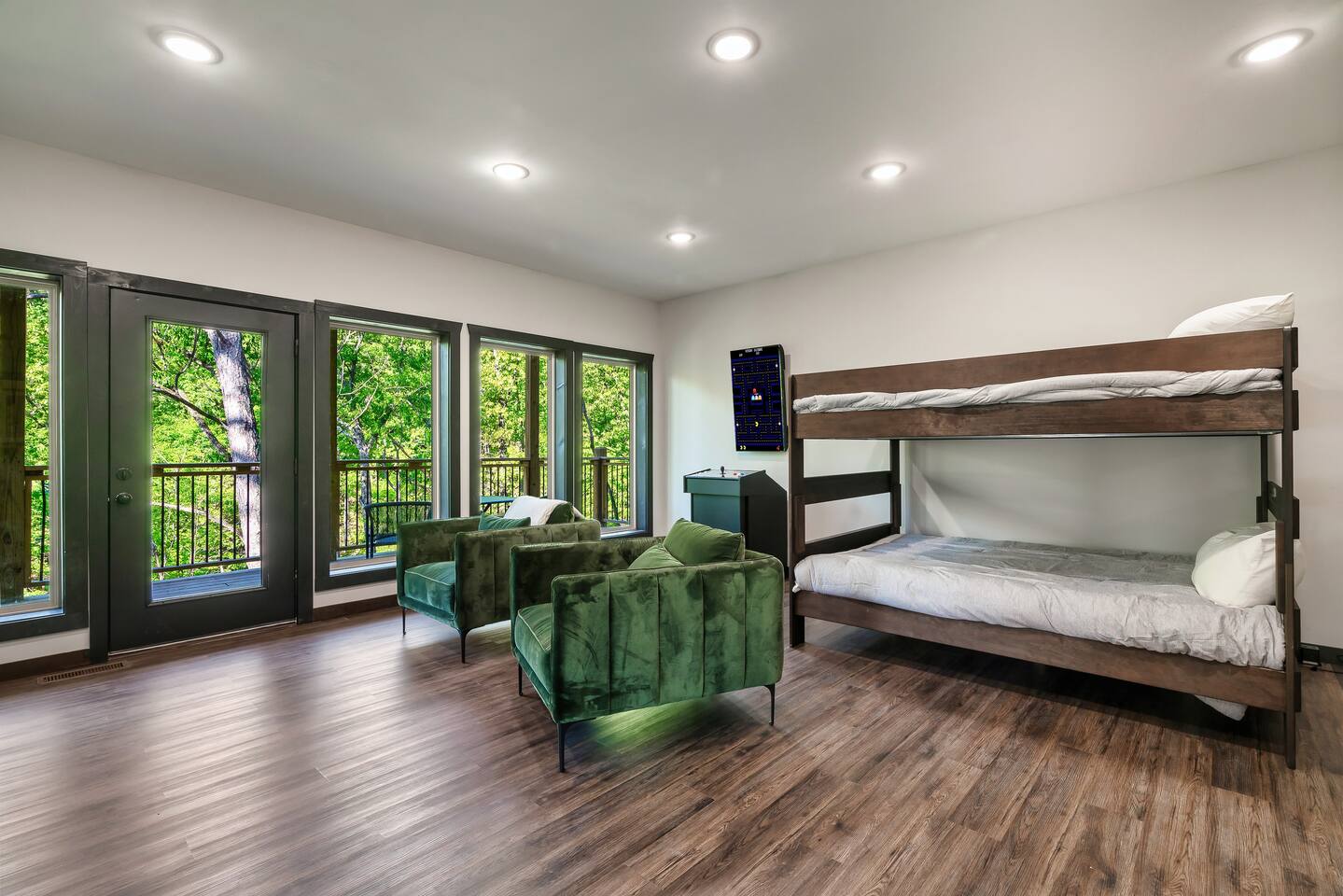 Bunk room with arcade game, balcony access, and extra lounge seating.