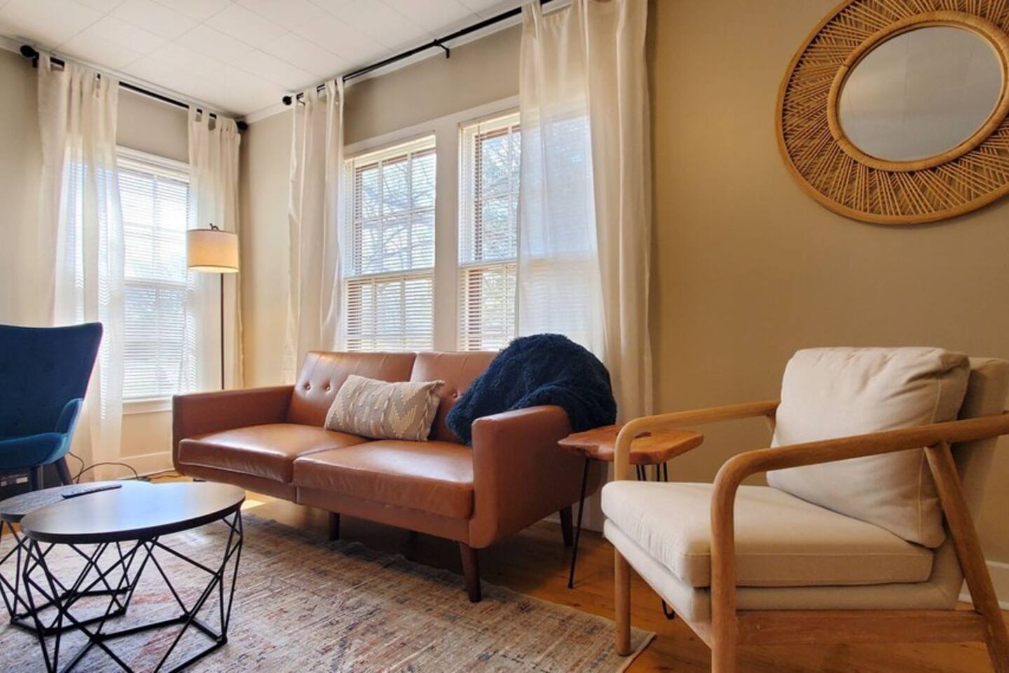 Cozy living room with a stylish leather sofa, soft throw, natural light, coffee table, and modern decor—perfect for relaxing or entertaining.