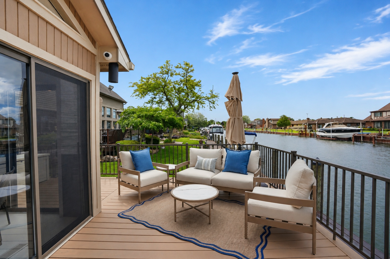 Outdoor lounge seating on a private waterfront deck with canal views. Relaxed, resort-style space perfect for entertaining, enjoying sunsets, and unwinding by the water.