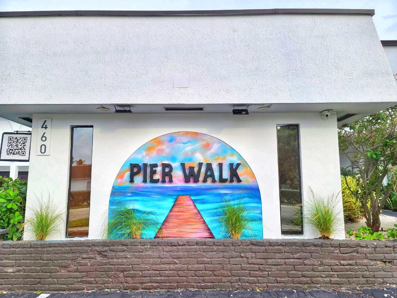 Our Pier Walk signage outside w/ our custom mural painted by local artist MSG Concepts and designed 100% by your host Danielle. Meet your guests easily at the Pier Walk sign on South Ocean Dr!