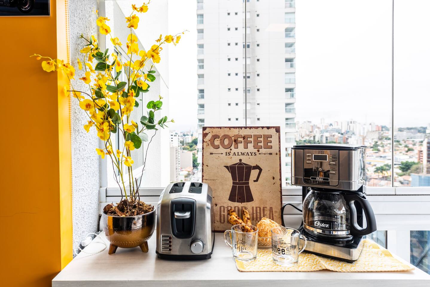 Cantinho do café com cafeteira, taças e decoração charmosa para começar o dia.