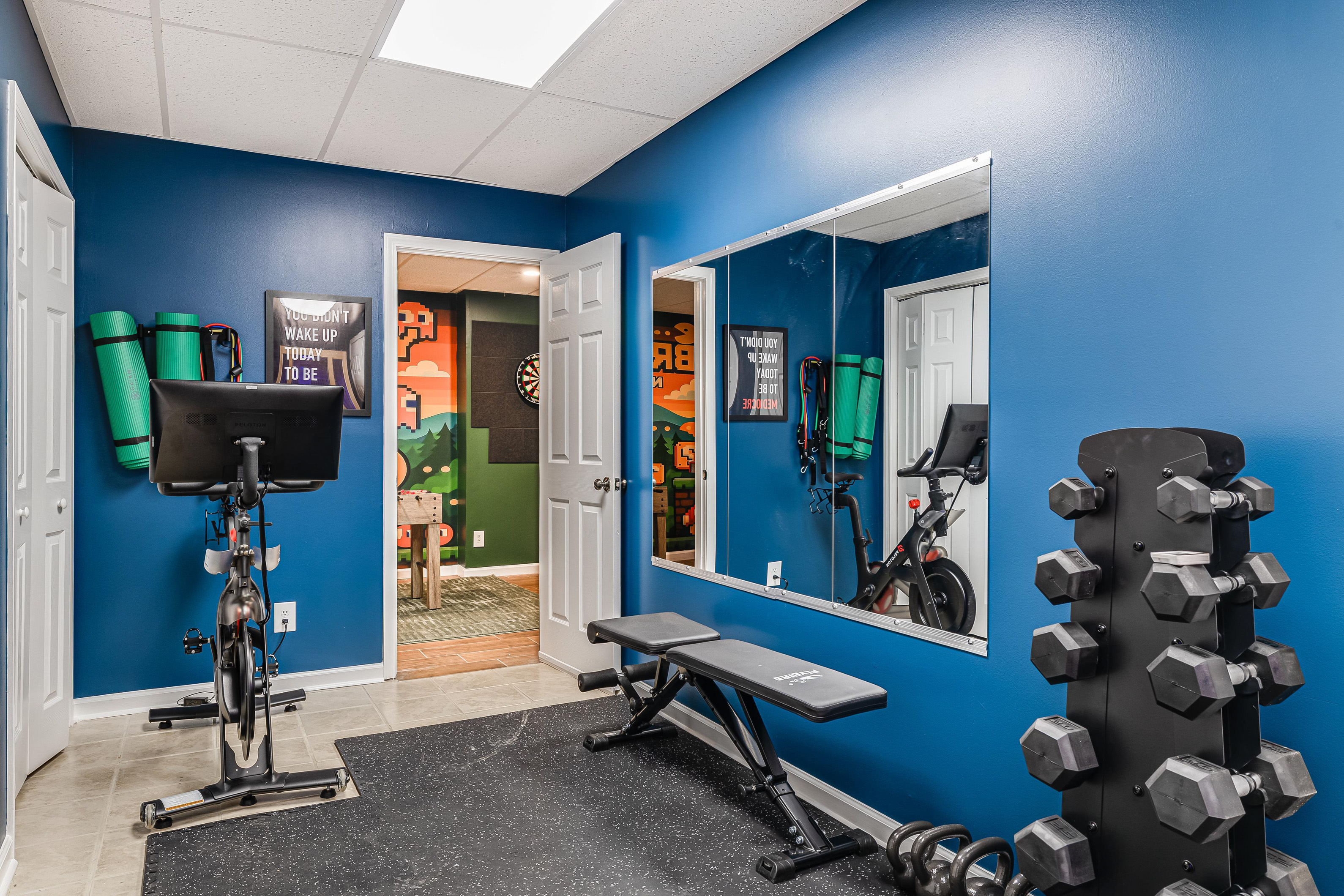 Enhance the gym amenities description by highlighting the specific equipment available: Our private gym features a Peloton bike, a dedicated workout bench with free weights, and 
