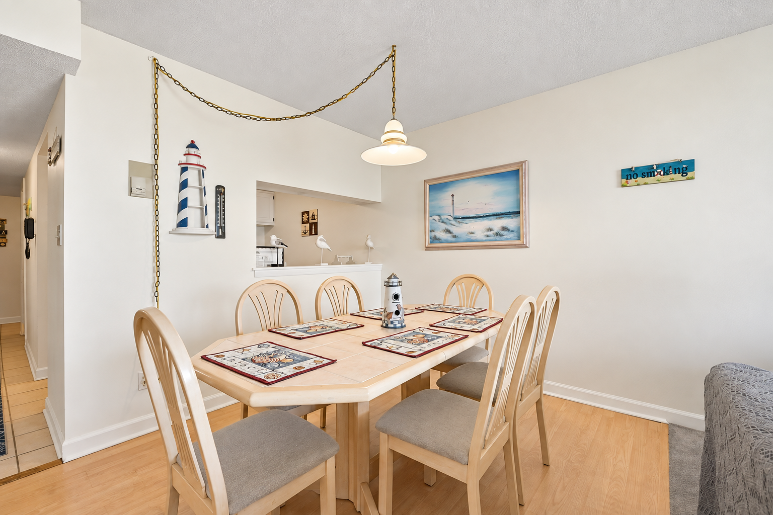 Dining area with seating for six, beach-themed touches, and an easy pass-through to the kitchen.