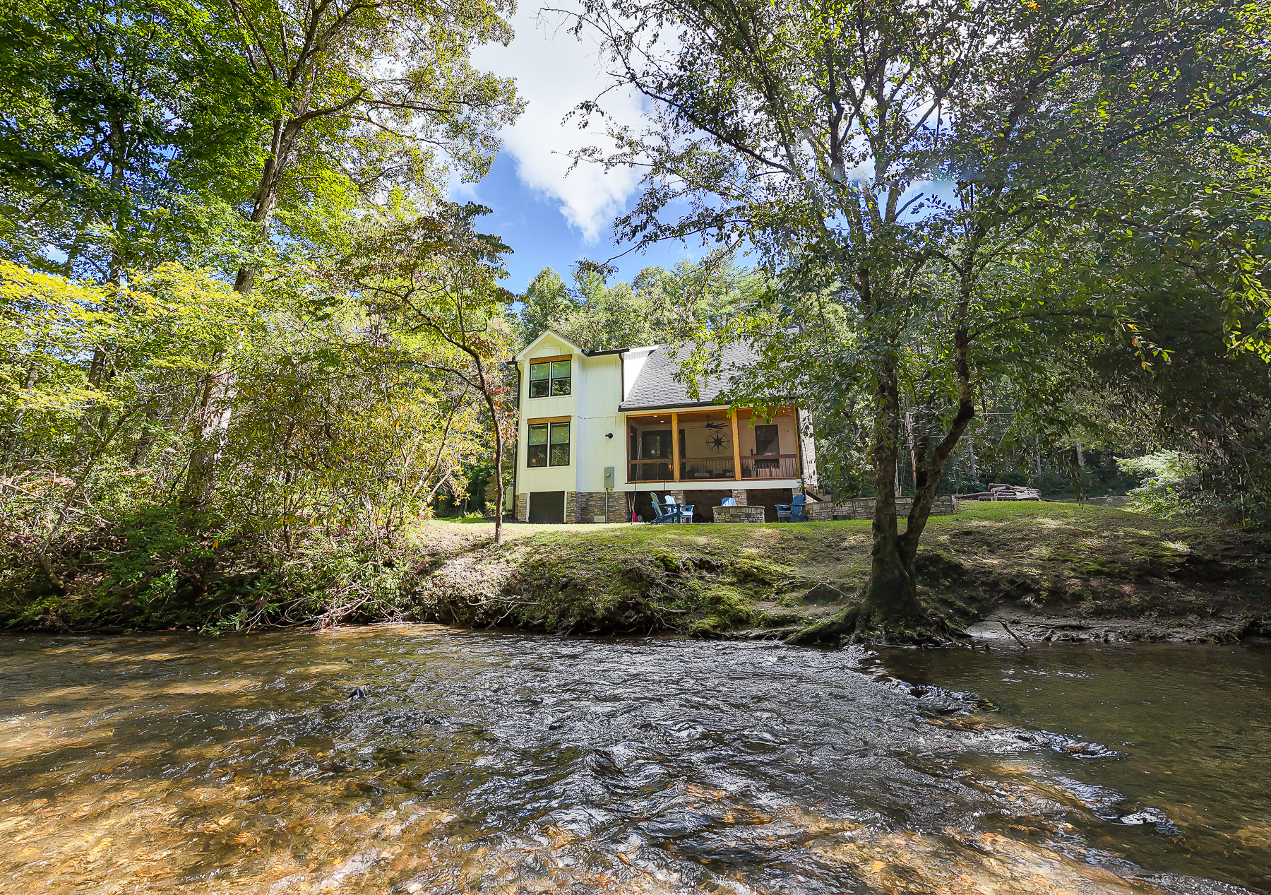 Robbin’s Nest on Snowbird Creek offers a peaceful waterfront setting, with a screened porch and outdoor fire pit overlooking the tree-lined creek.