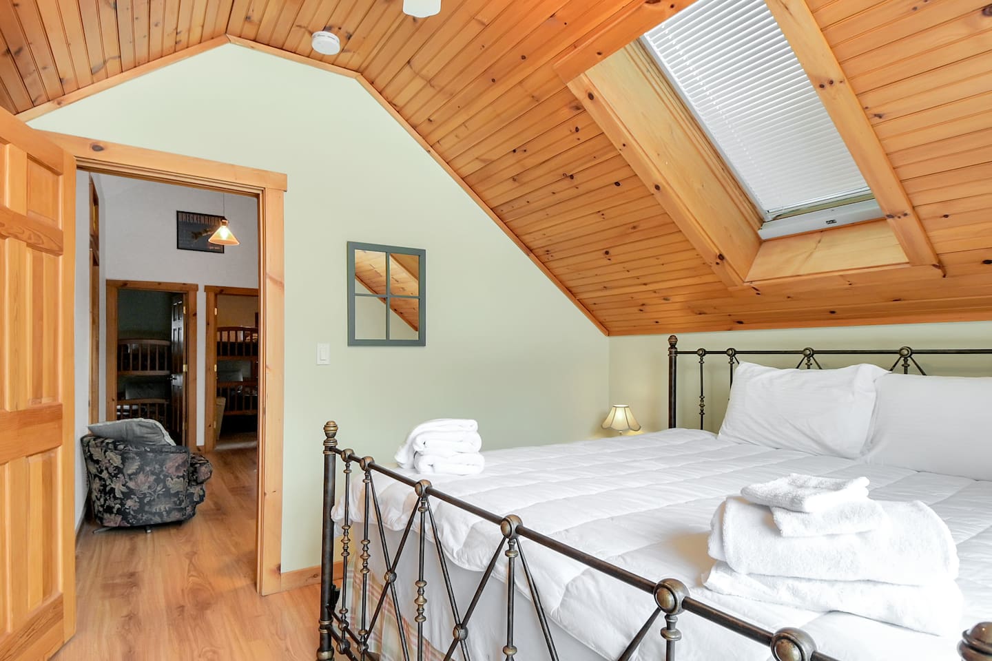 This spacious bedroom features a vaulted ceiling, skylights, and a plush king bed for ultimate relaxation.