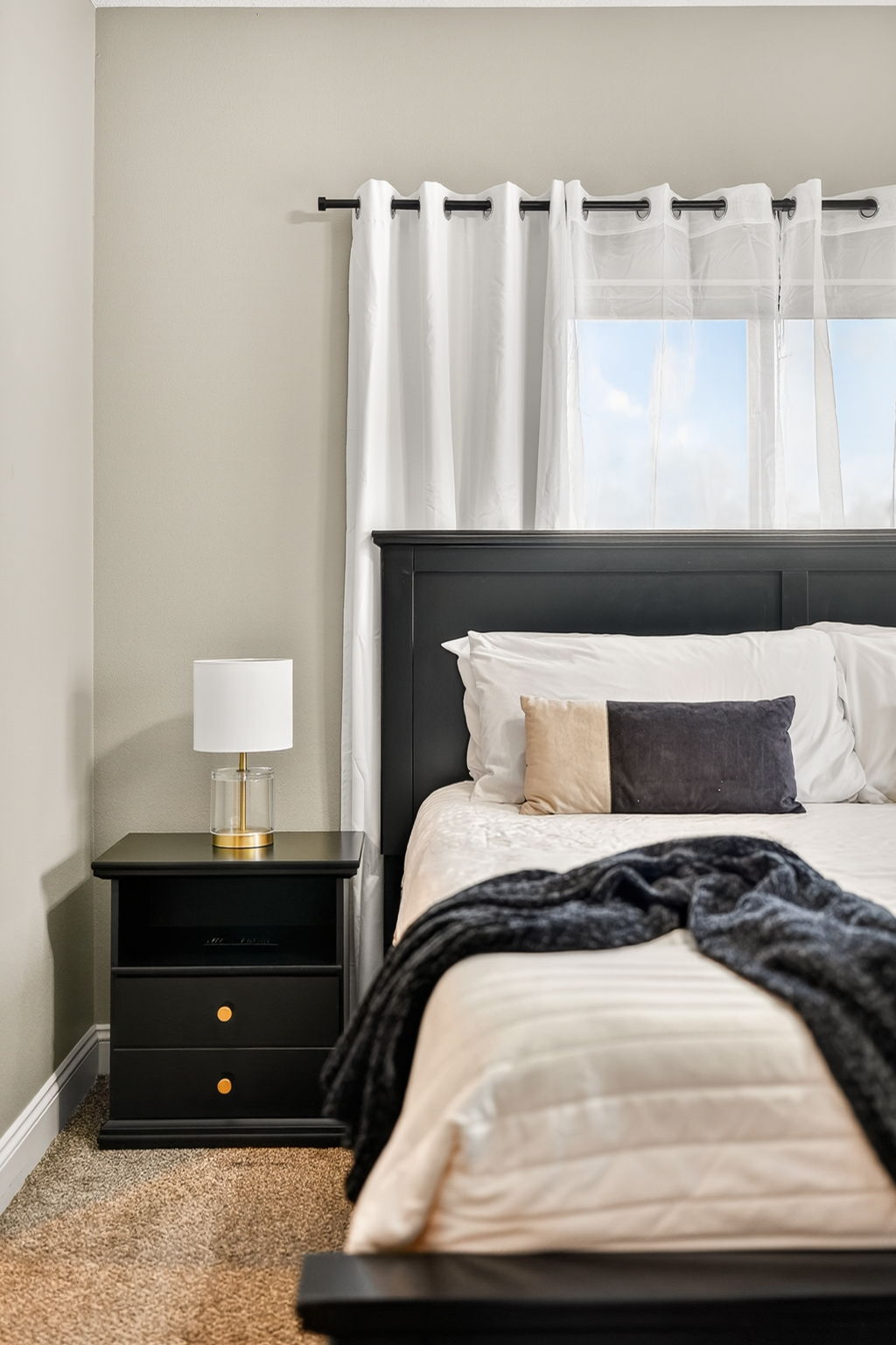 Layered bedding and throw blanket create a restful, inviting atmosphere.