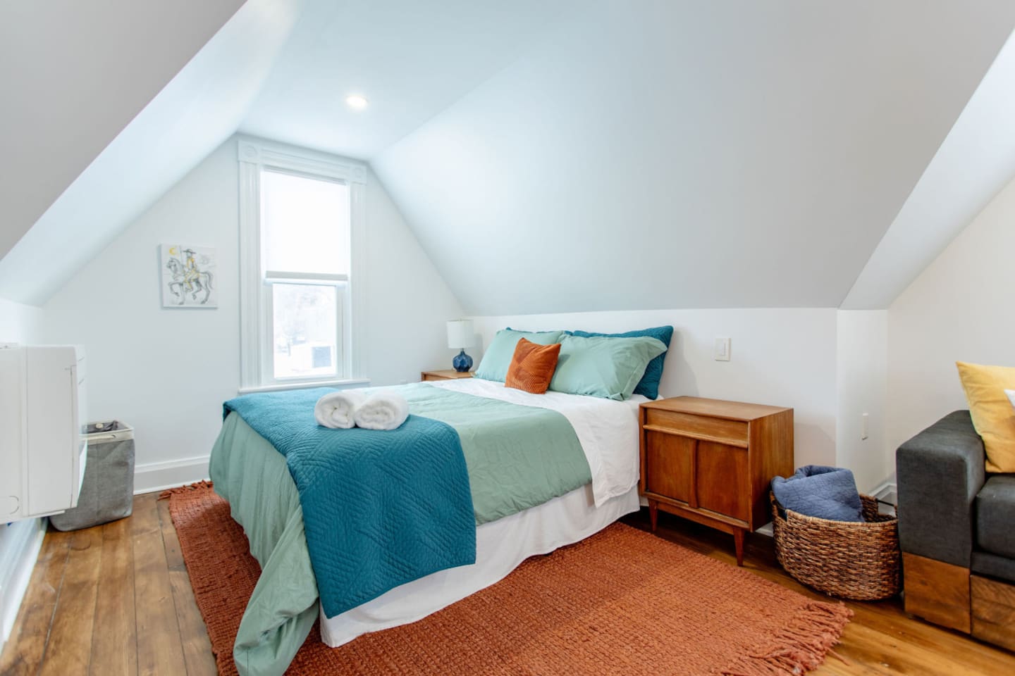 A cozy bedroom featuring a comfortable queen-sized bed, with soft linens and a large window that brings in natural light, creating a bright and peaceful retreat.