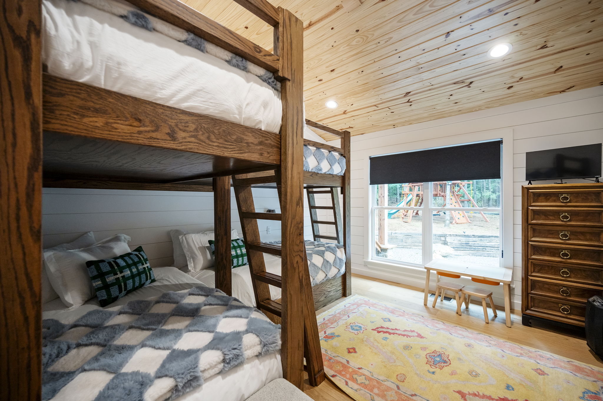 The stylish bunkroom features four twin beds, cozy designer touches, and high-end linens—creating a comfortable and welcoming retreat for kids or additional guests.