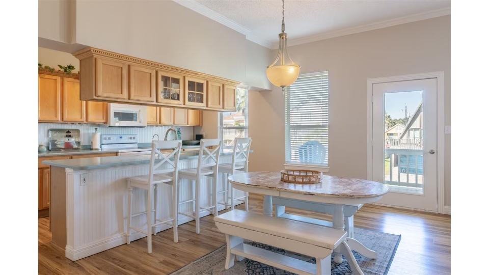 The spacious kitchen island provides extra prep space and casual seating for quick breakfasts or afternoon snacks. Just steps away, the farmhouse-style dining table with bench seating comfortably accommodates your group for memorable meals together.