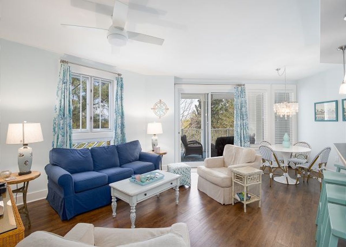 Living room with queen sleeper sofa, ceiling fan and sliding doors opening to the balcony