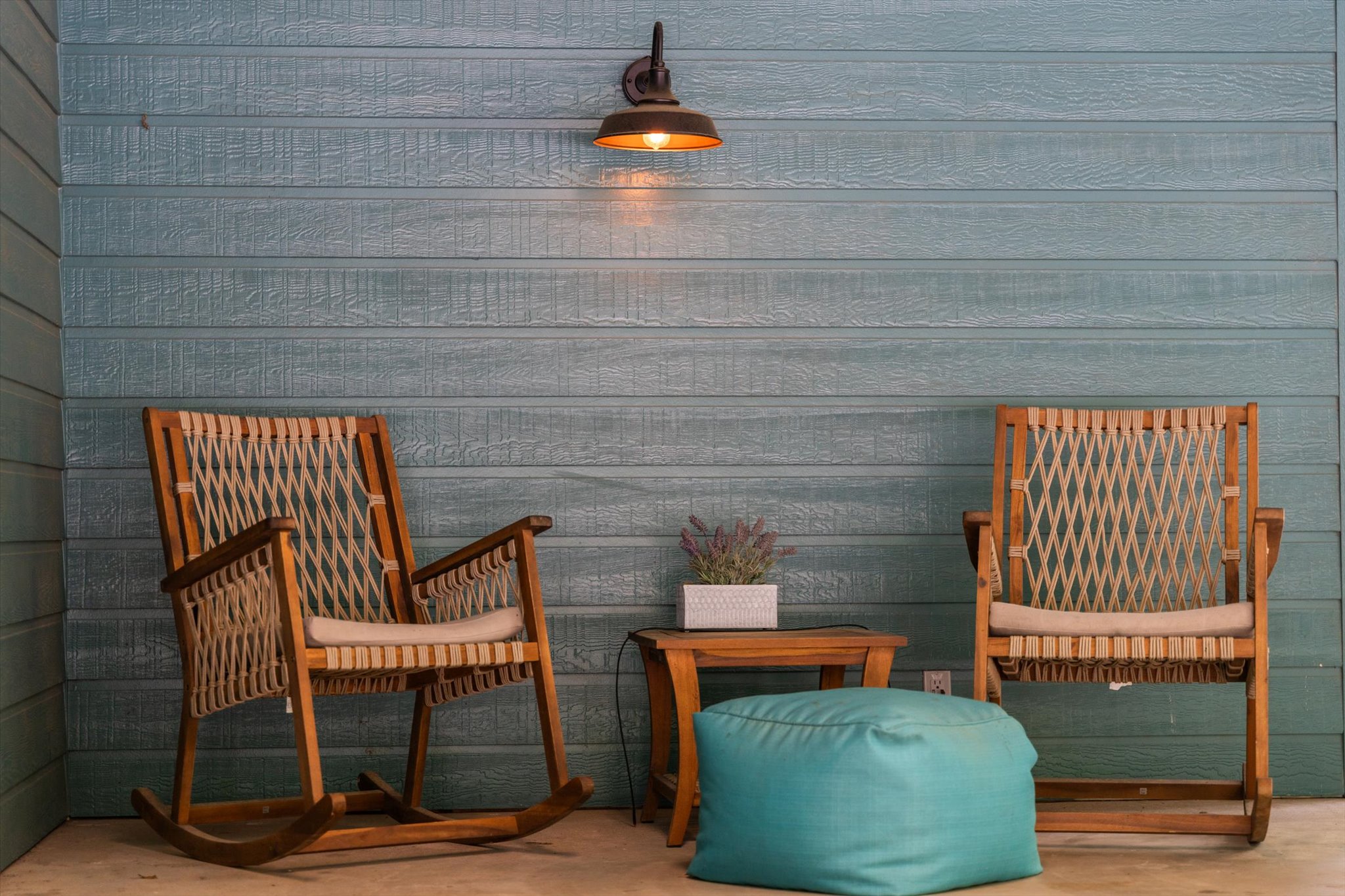 A cozy seating area on the two-car carport, perfect for unwinding. With rustic rocking chairs, warm lighting, and a peaceful ambiance, this inviting spot is ideal for enjoying a quiet moment outdoors.