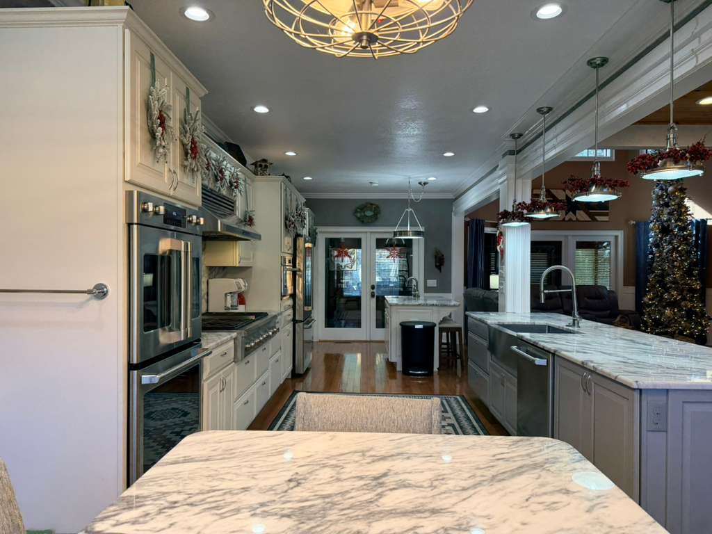 Seamless flow from cooking to celebrating! This view shows the expansive Chef's Kitchen opening directly into the Great Room, ensuring the host is always part of the holiday fun.