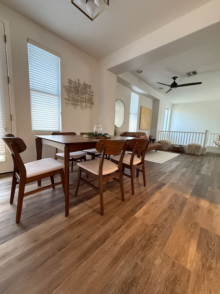 Dining area with table seating, natural light, and an open view toward for the lounge space.