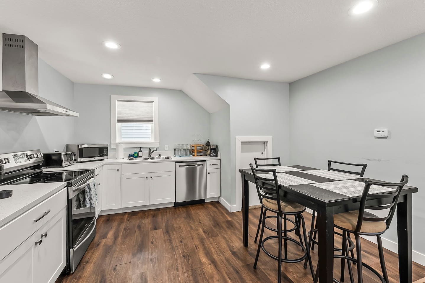 Dining table positioned beside the kitchen for effortless serving and casual family-style dining.