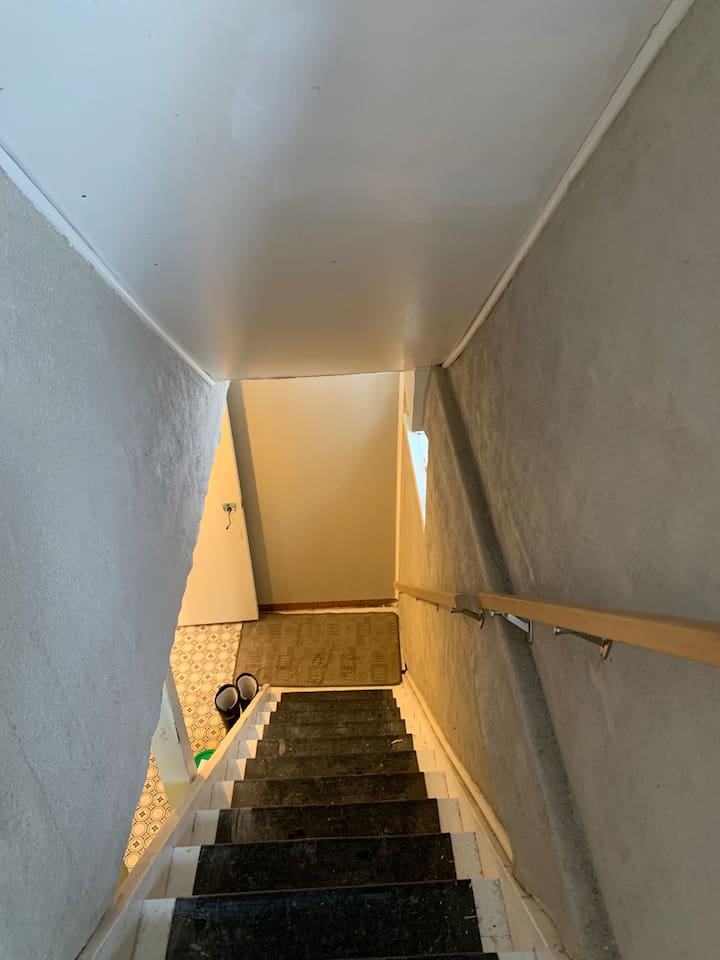 Shared downstairs stairway to the shared laundry room located outside of the private main-floor suite. 