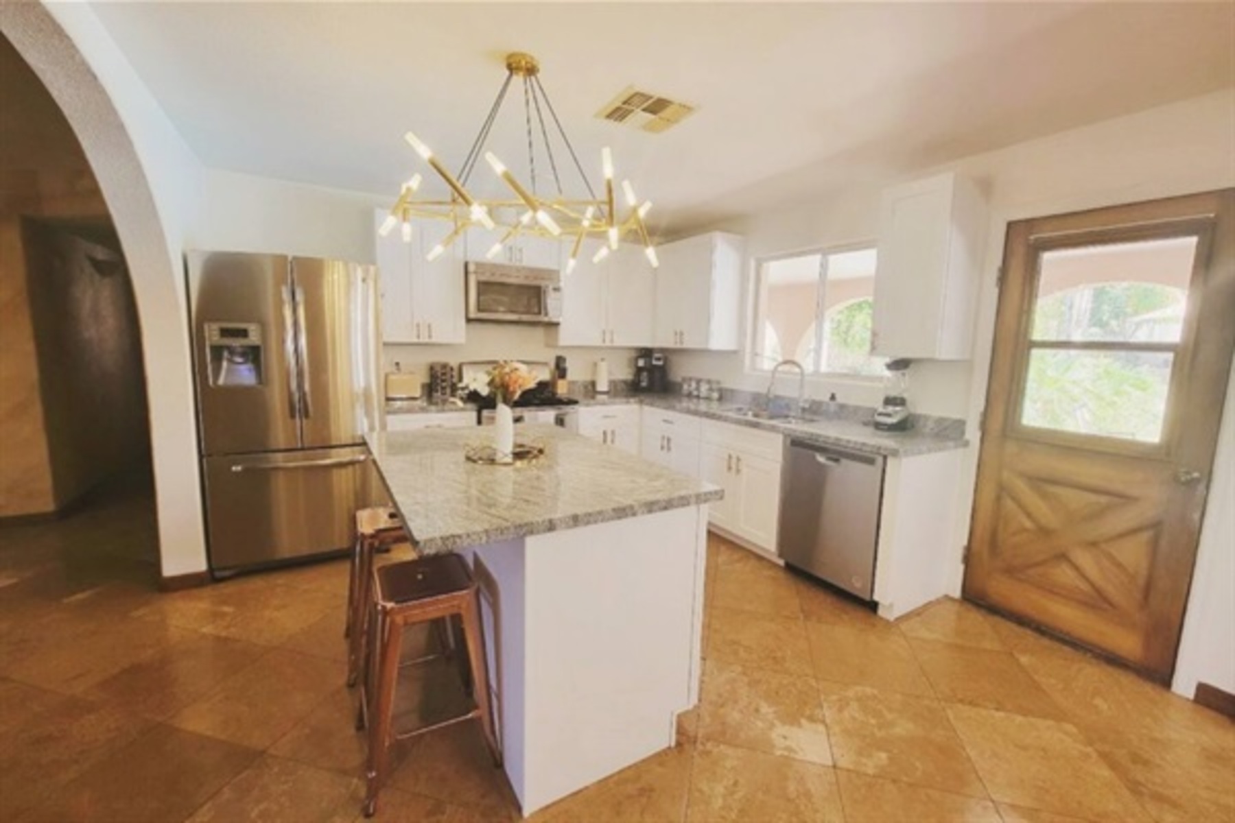 This modern kitchen features stainless steel appliances, sleek granite countertops, and a central island perfect for morning coffee or evening cocktails.
