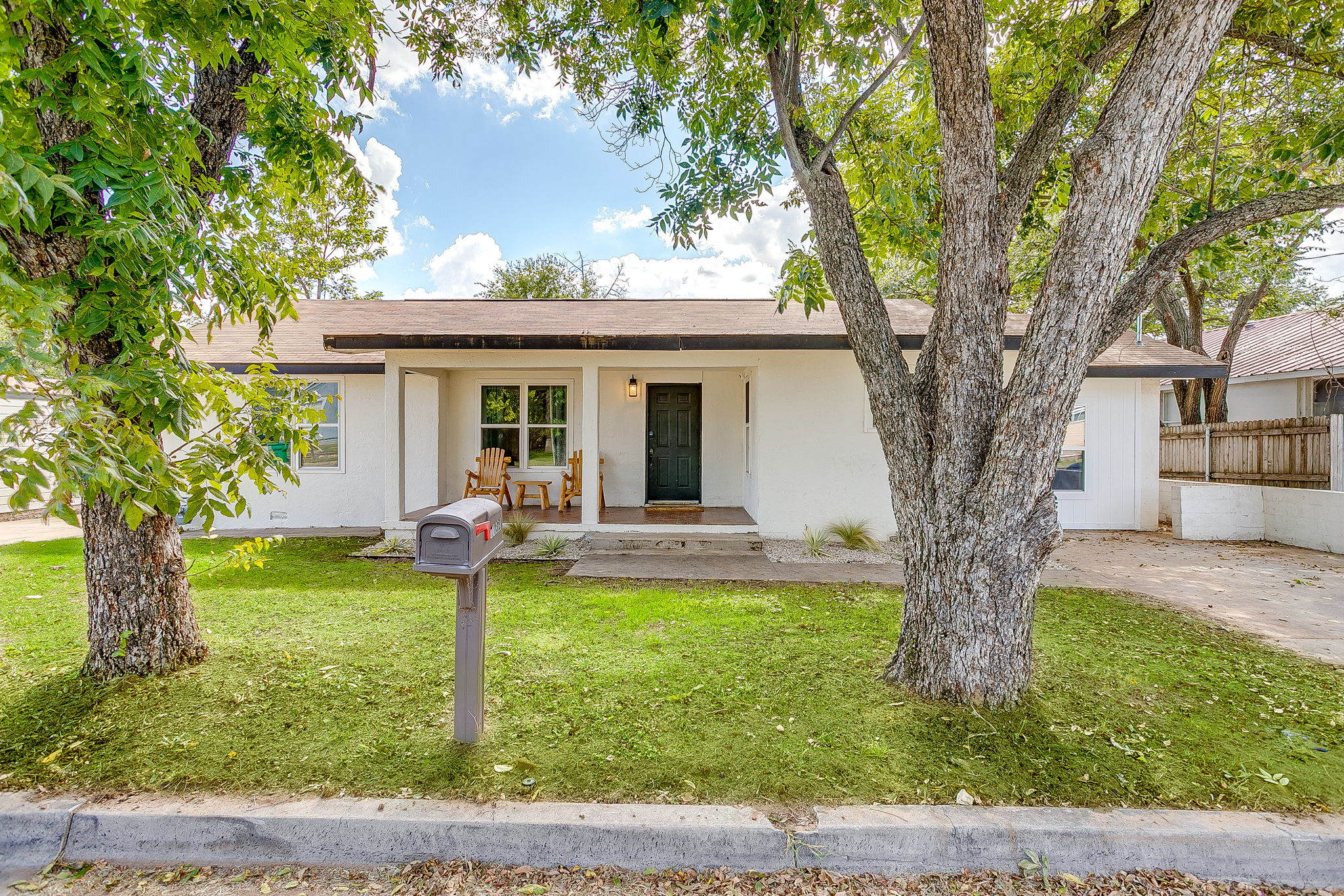 Welcoming front yard with mature trees and covered walkway