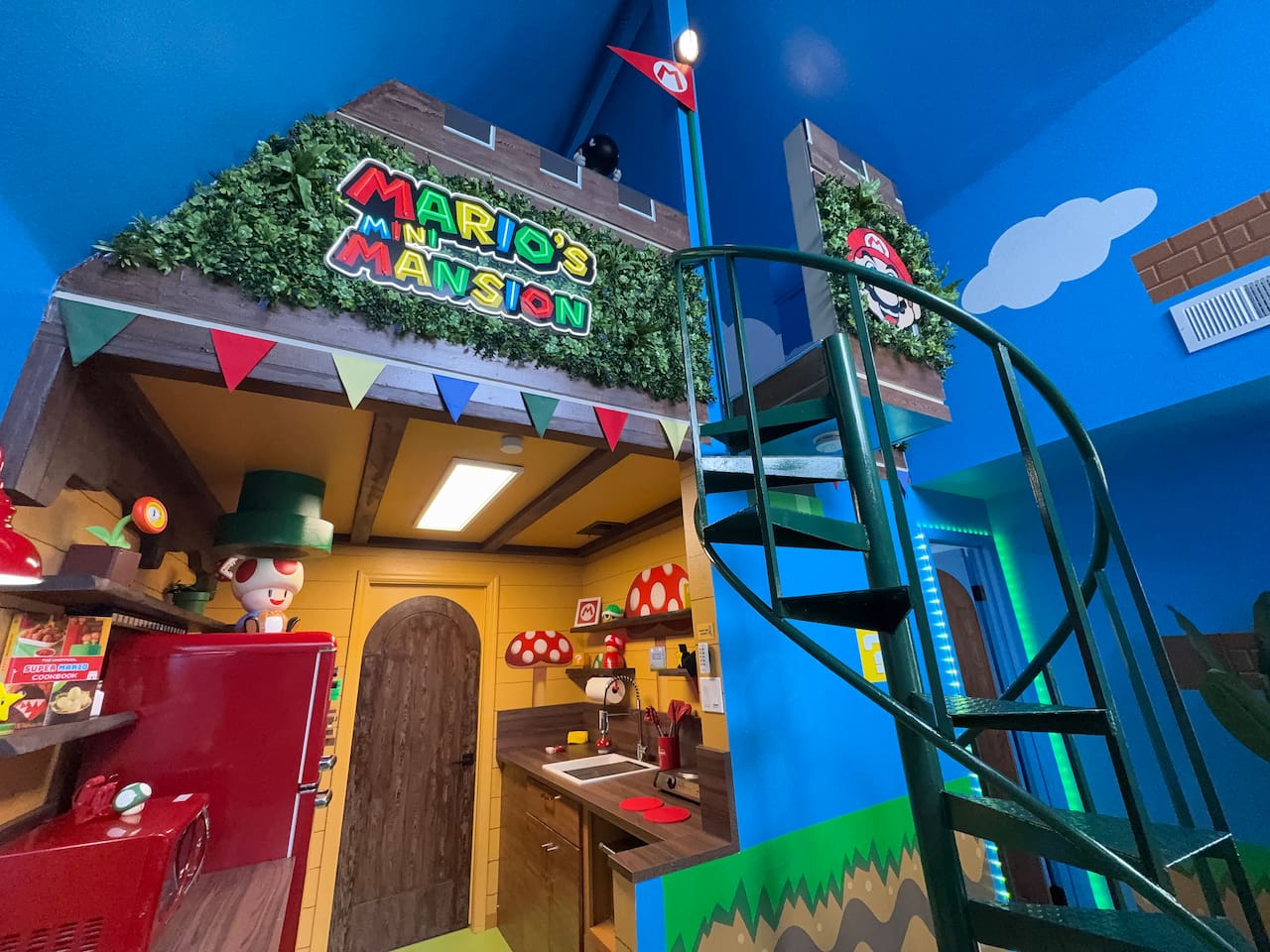 Adventure awaits in this custom Mario themed house! Spiral staircase, green vines, red flags, Mario & Toad signs, and brick-pipe details create the ultimate play zone in our Clermont, FL Airbnb living room. Perfect for unforgettable family memories.