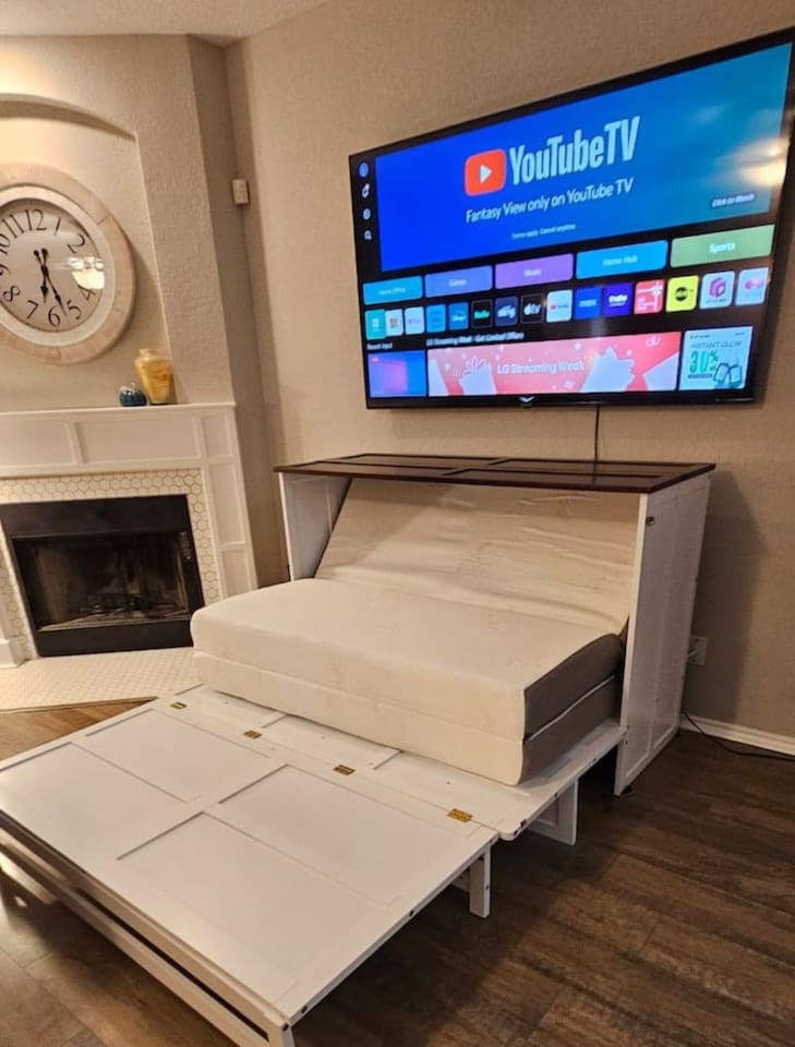 Living room cabinet converts into a pull-out murphy bed, offering flexible sleeping space for families and groups.