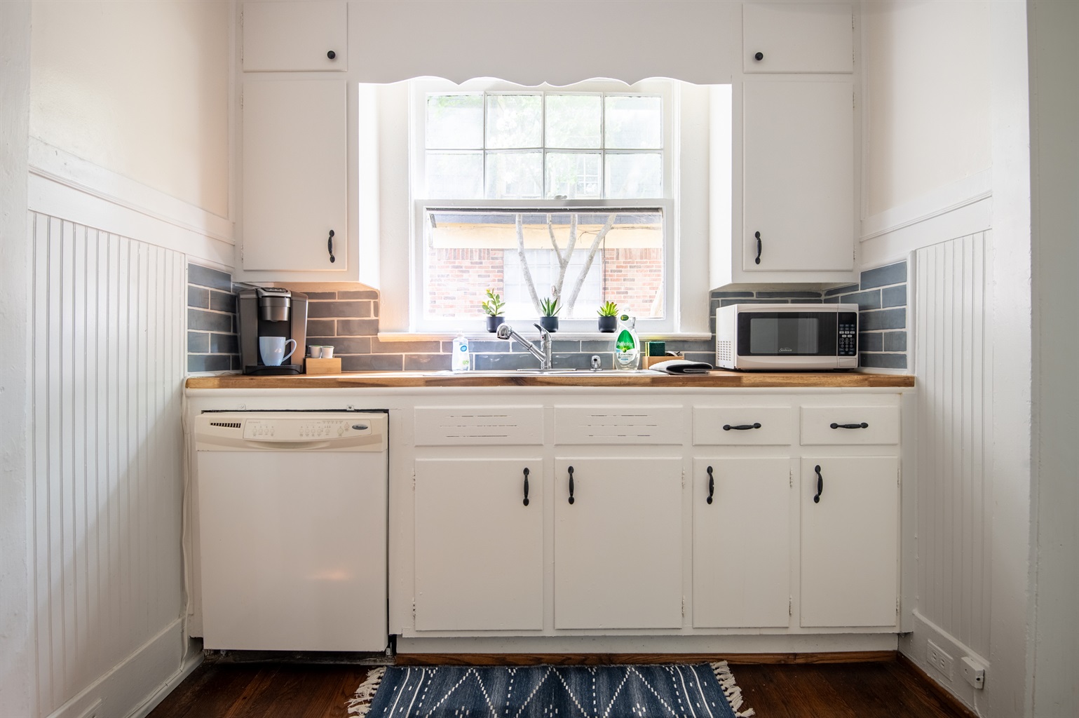 Sunny kitchen with coffee maker, toaster, and microwave to start your mornings right.