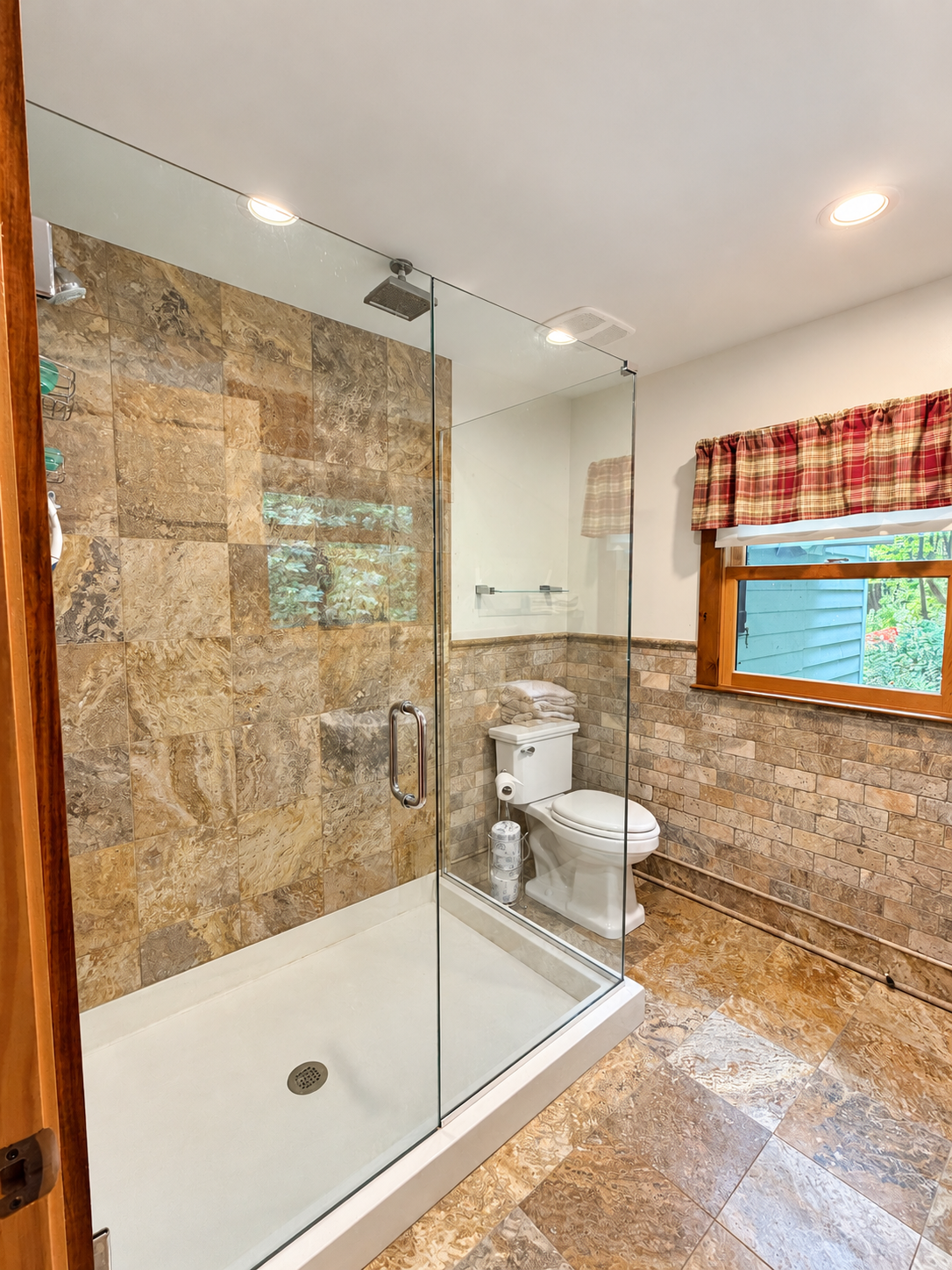 Bathroom with wide tiled shower and frame-less glass surround