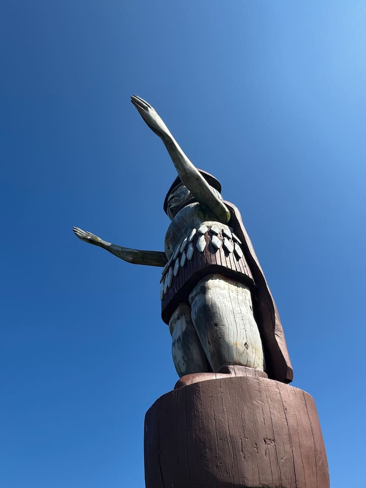 Skwxwú7mesh (Squamish) Welcome figure at Ambleside Beach nearby in carved red cedar
