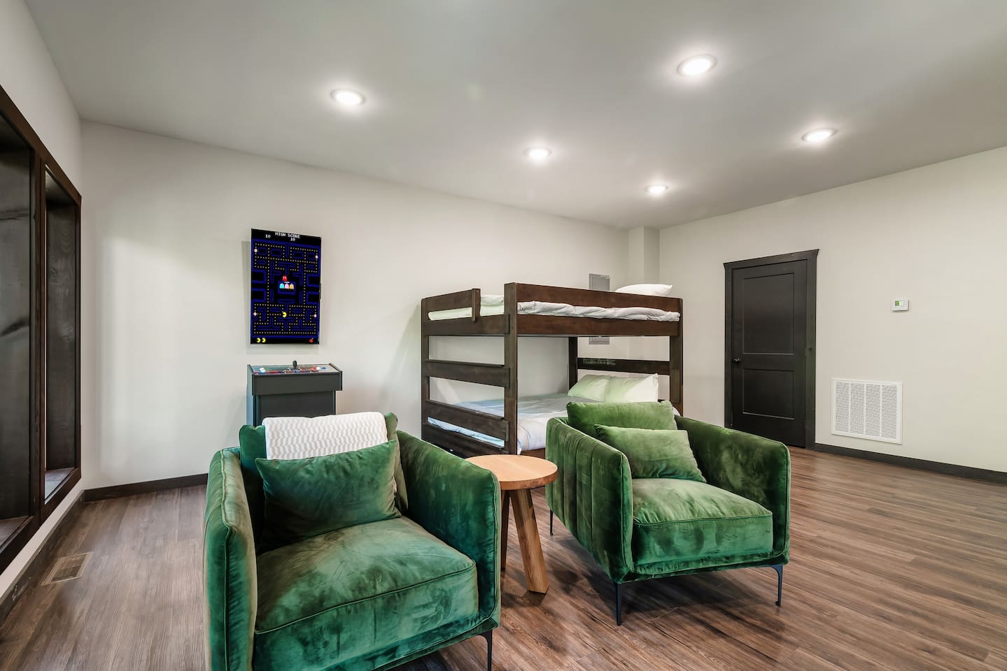 Fun bunk room with arcade game and cozy lounge seating.