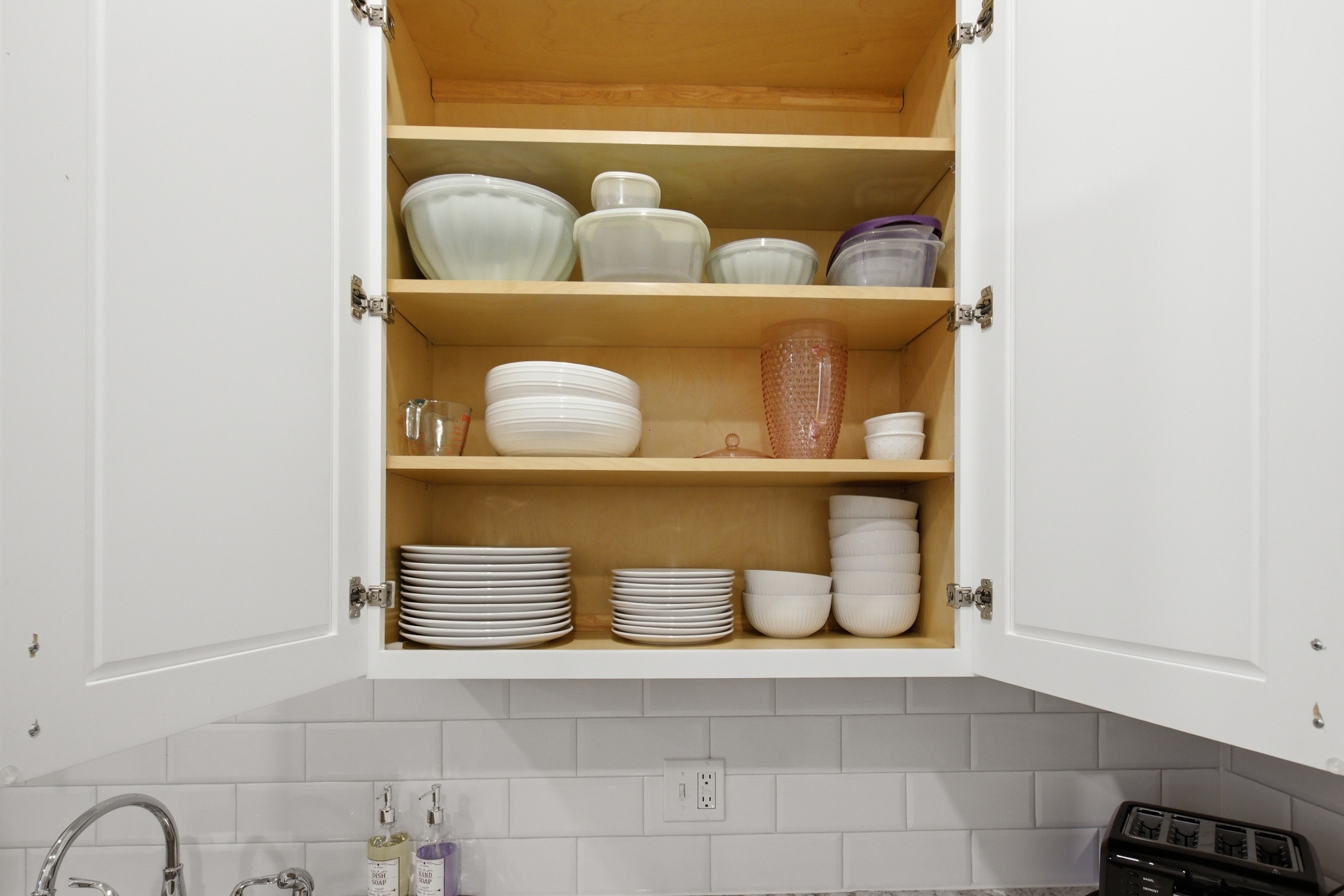Open cabinet storage with full dish and cookware supply. Baking Sheet and cooking essentials fully stocked for every stay.