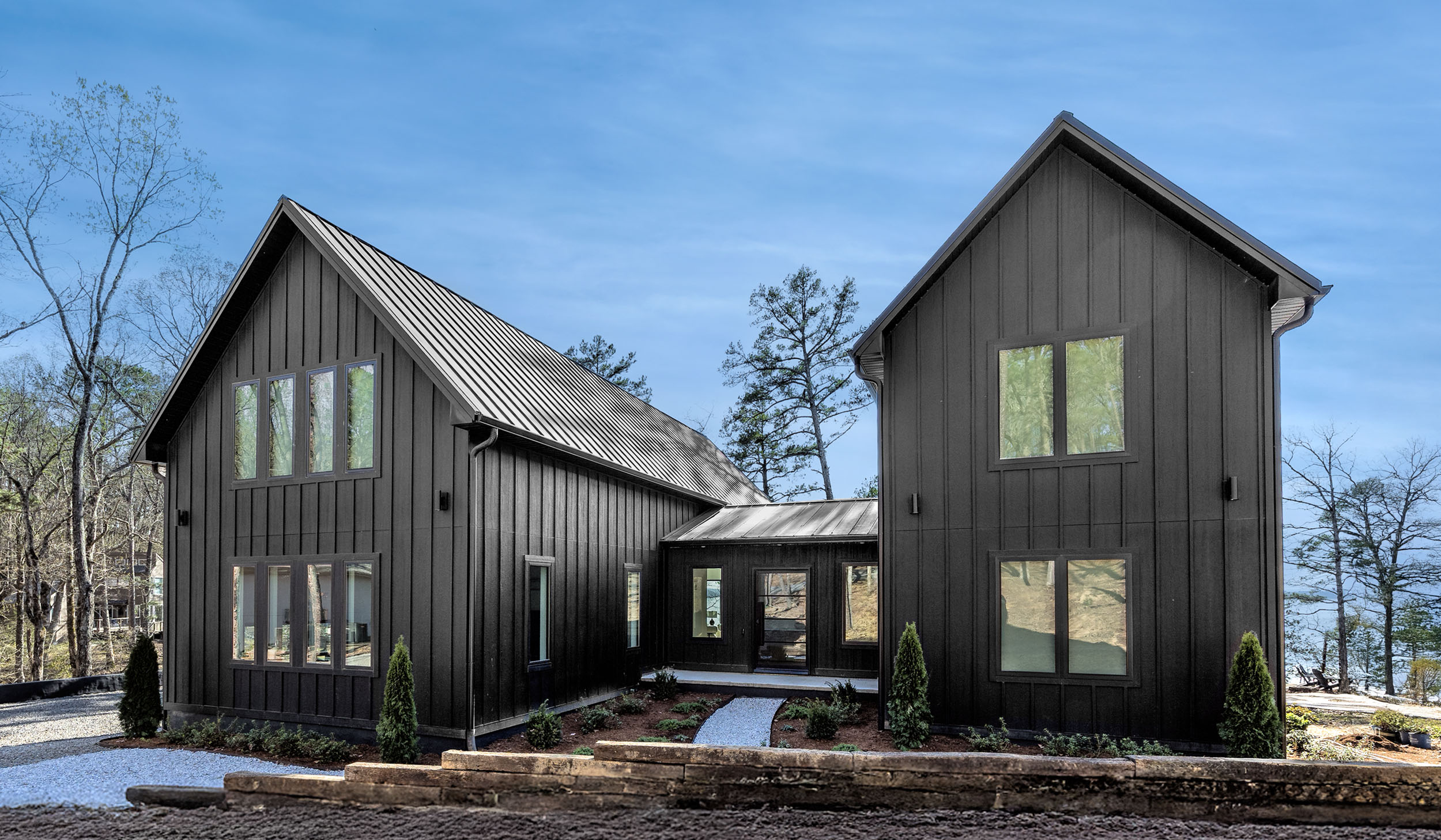 A bold modern retreat with timeless charm—Sunset Cove’s sleek black exterior welcomes your group to a peaceful lakefront escape.