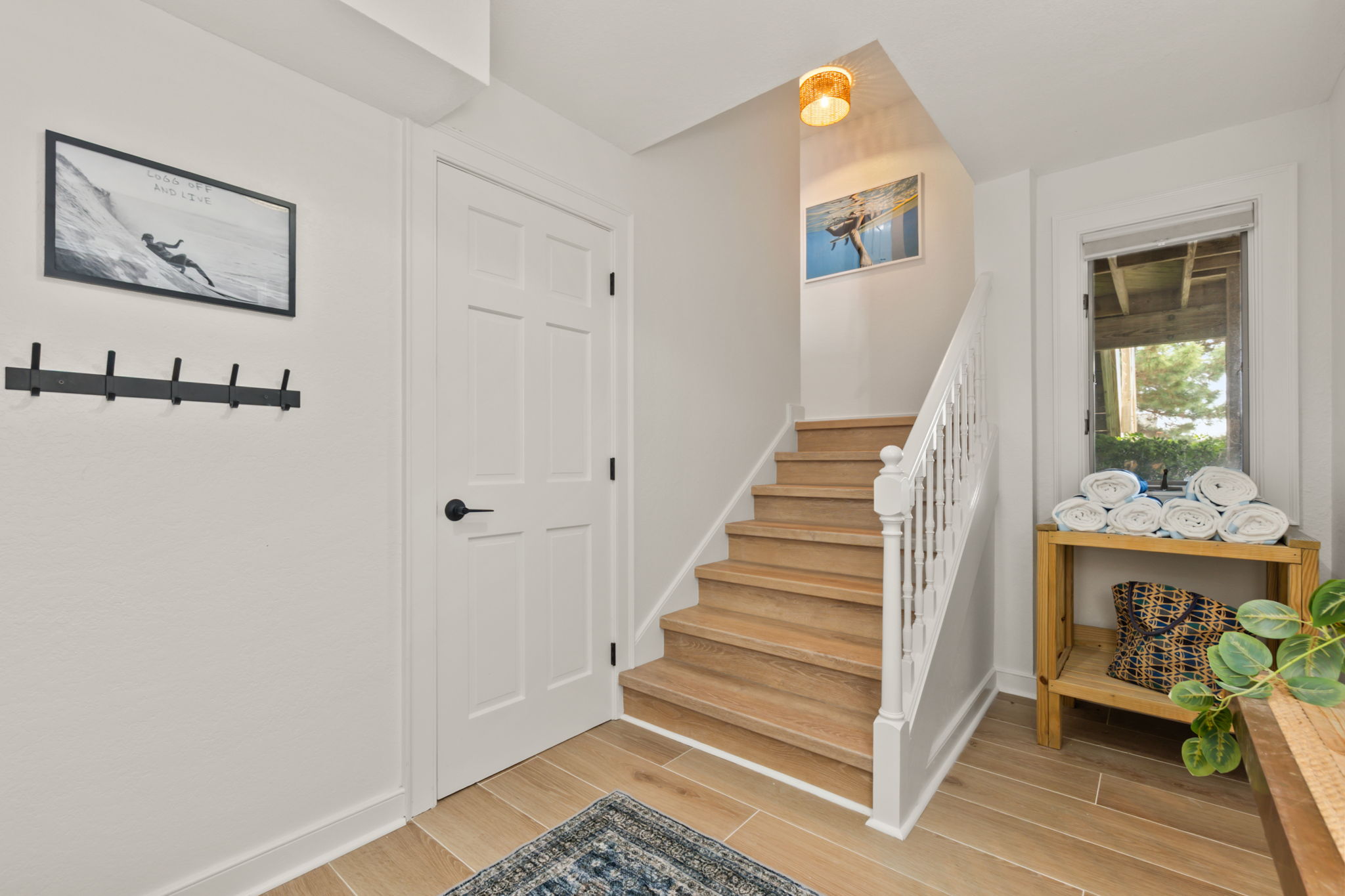 Entry area with stairs, hooks for hanging items, and a clean, welcoming feel.