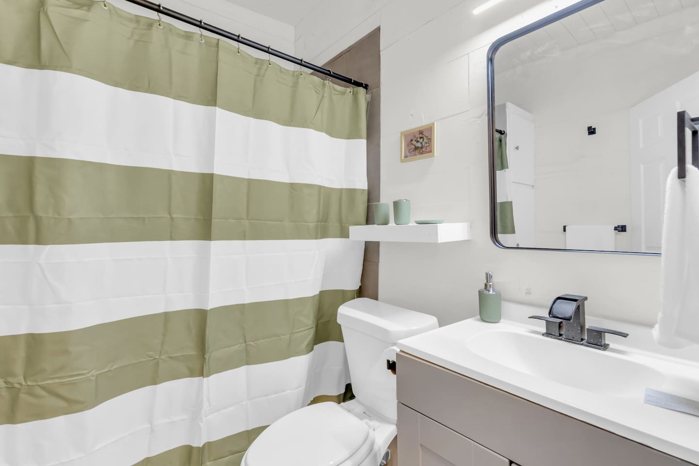 Bathroom with ample storage space, premium bath products, and a rain shower head.